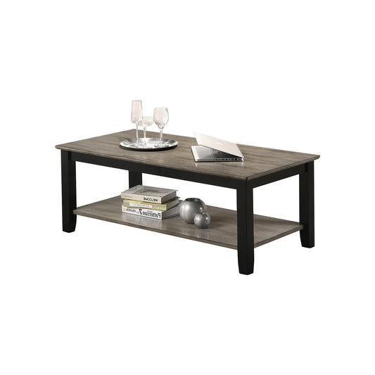 Rustic gray wood coffee table with black frame and lower shelf holding books and decor