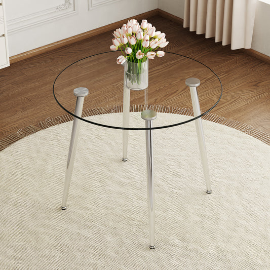 Round glass dining table with chrome legs and a vase of pink tulips