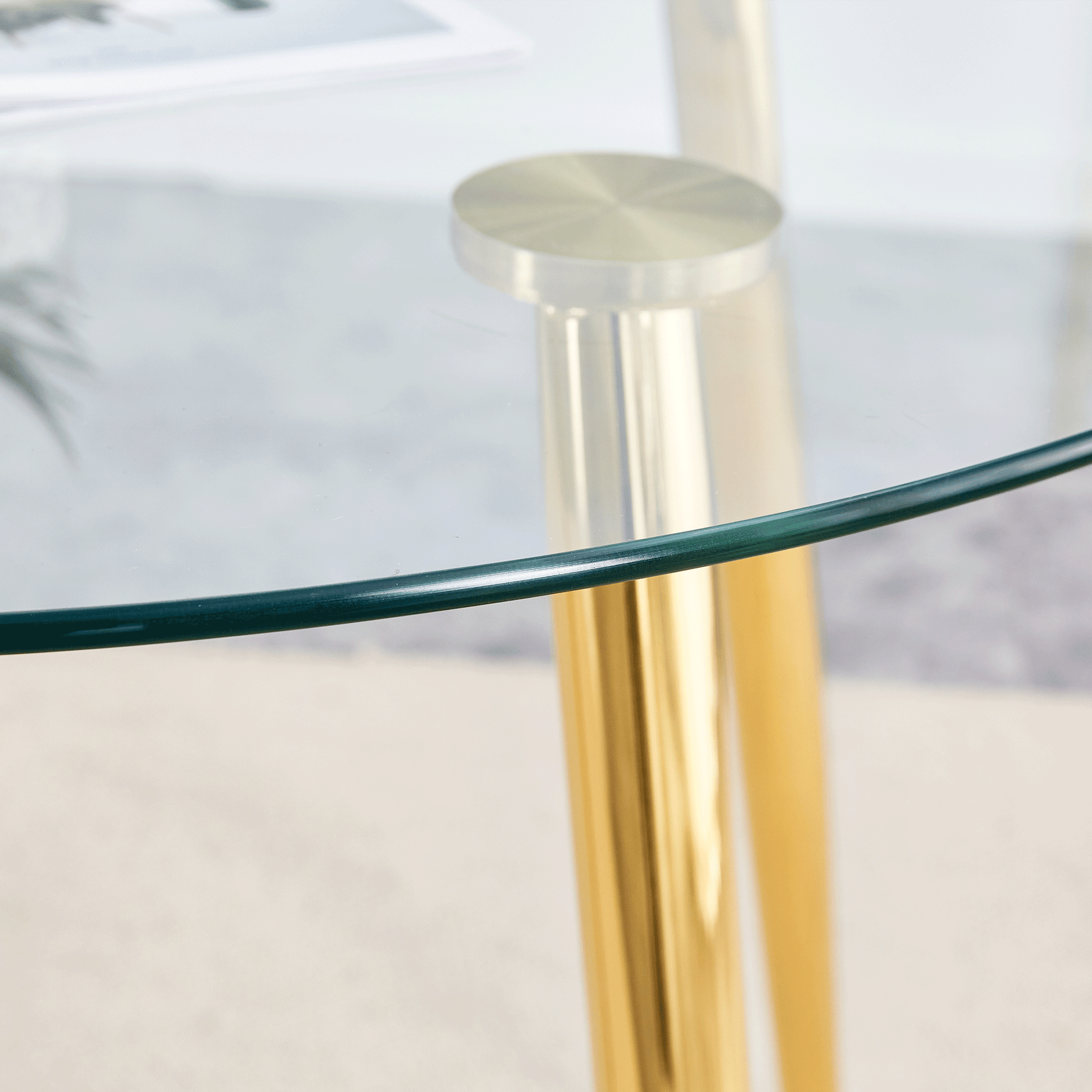 Elegant round glass coffee table with polished brass legs