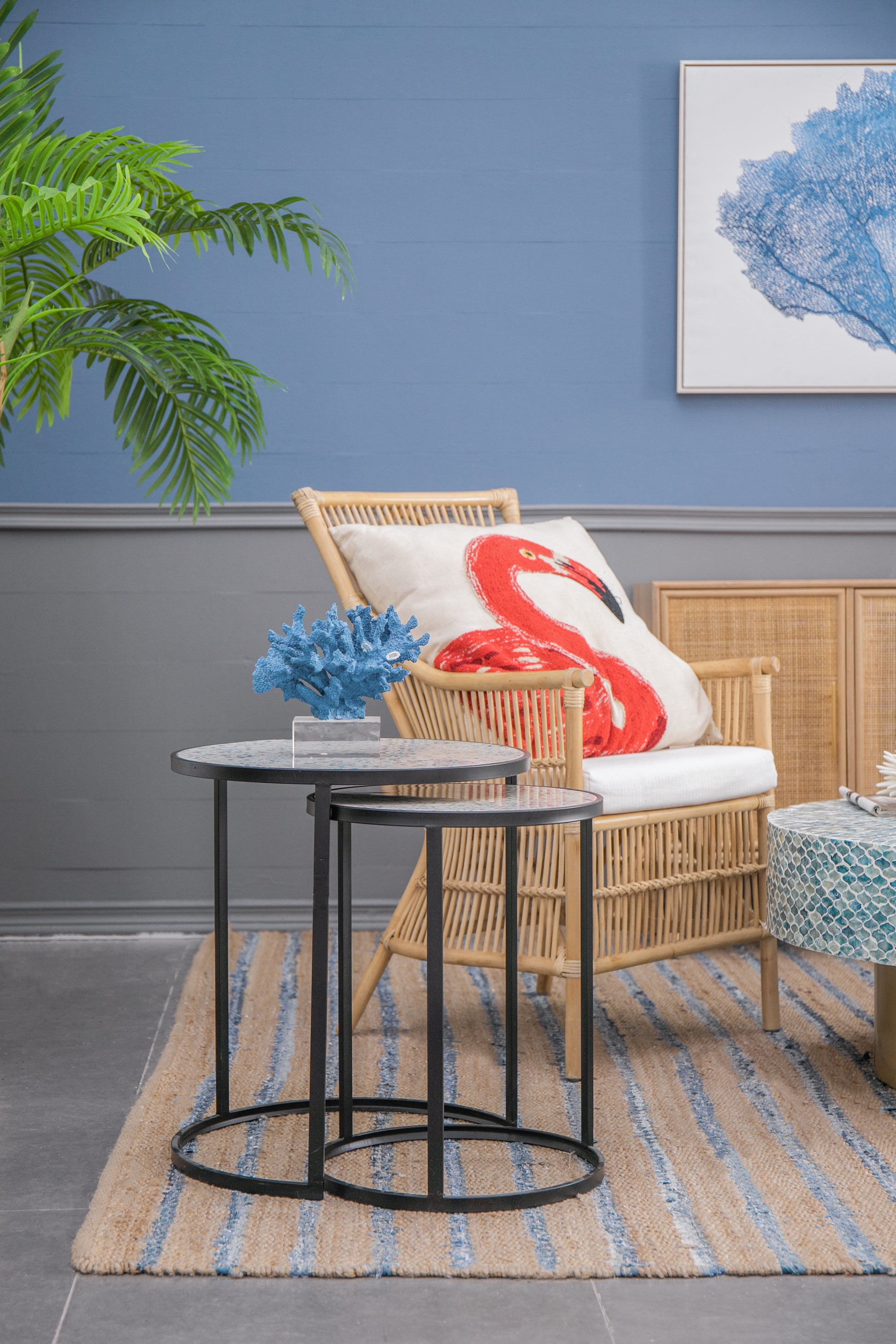 Woven rattan armchair with white cushion featuring a red flamingo accent perfect for a beachthemed living room