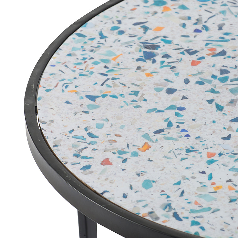 Round side table with a white terrazzo top featuring blue teal and orange chips