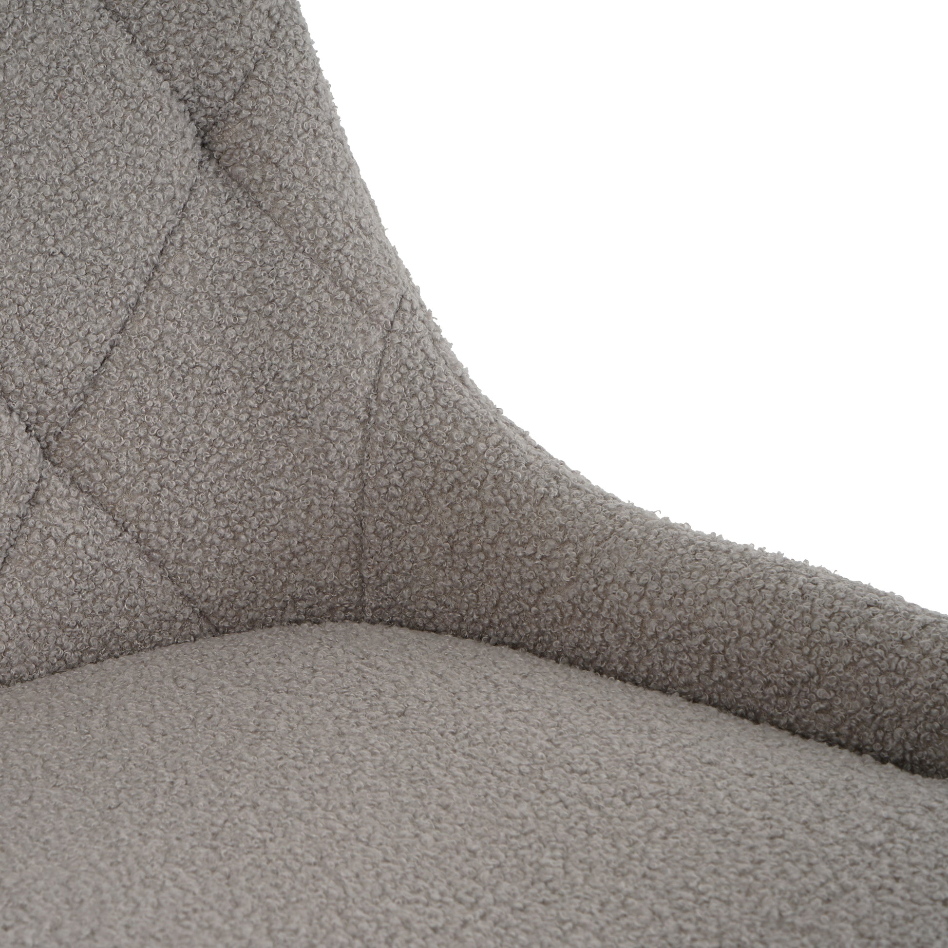 Closeup of a grey boucle fabric accent chair with diamond tufting detail