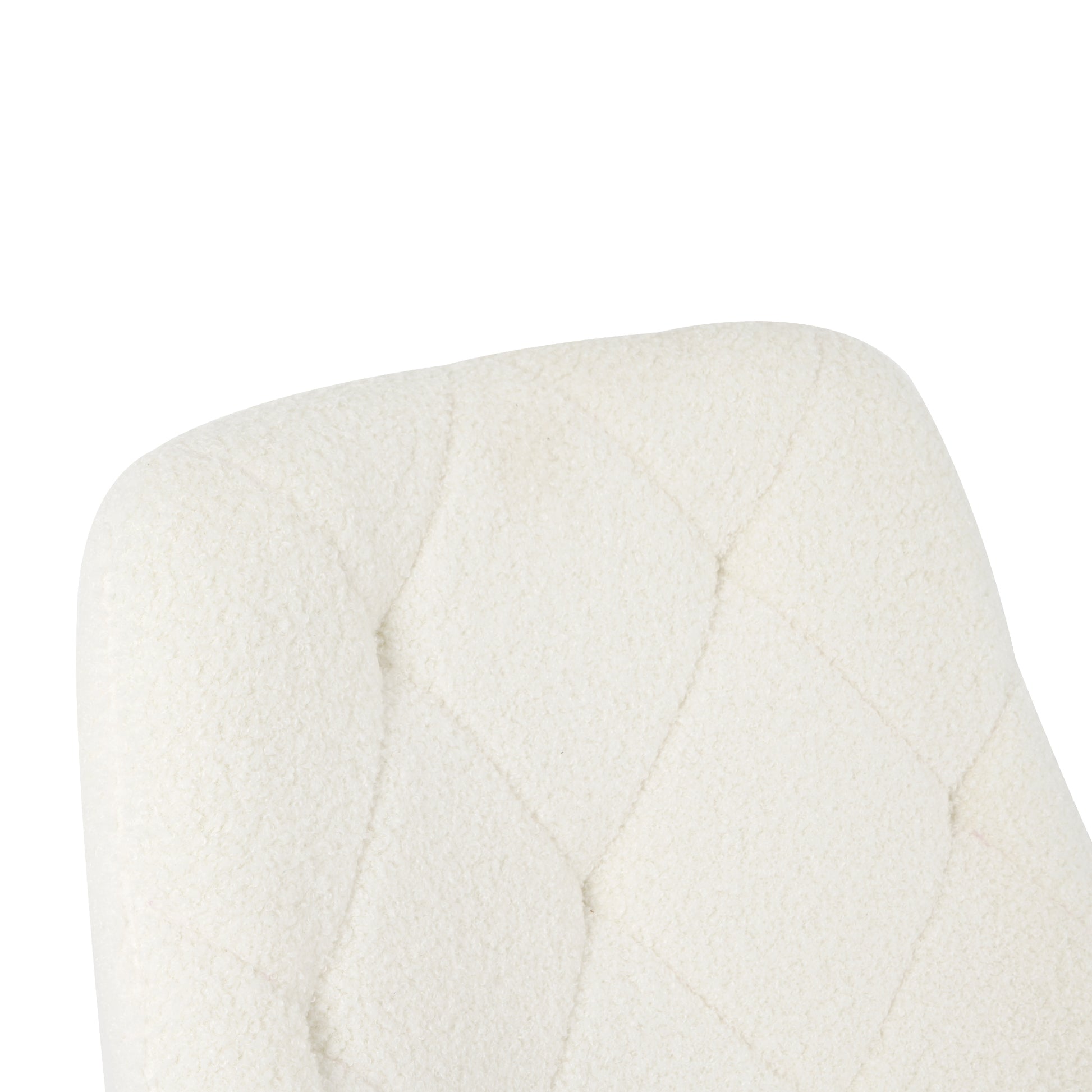 Closeup of a cream boucle fabric armchair backrest with diamond tufting
