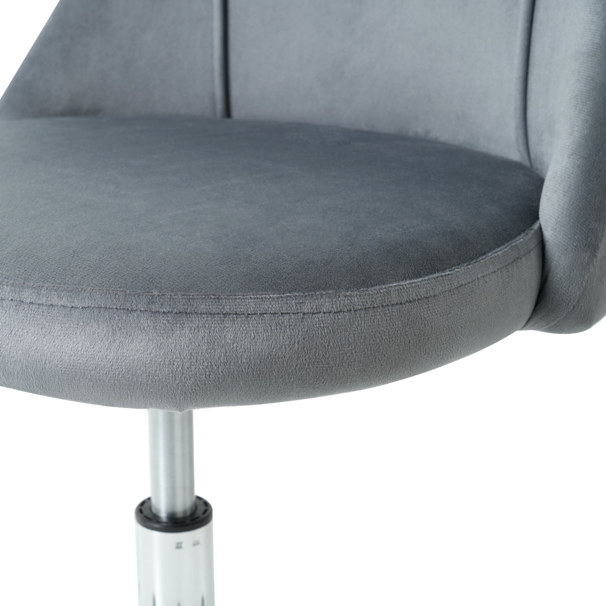 Closeup of a plush grey velvet chair seat with detailed stitching and a silver metal base
