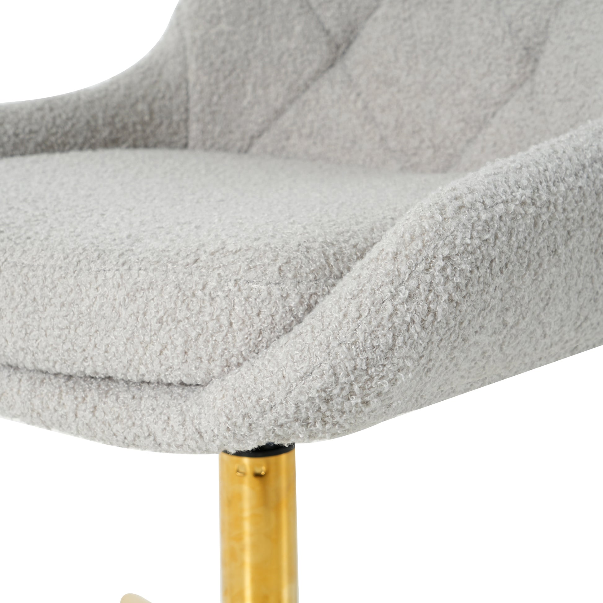 Closeup of a plush grey boucle fabric bar stool seat with a textured finish and diamond tufting
