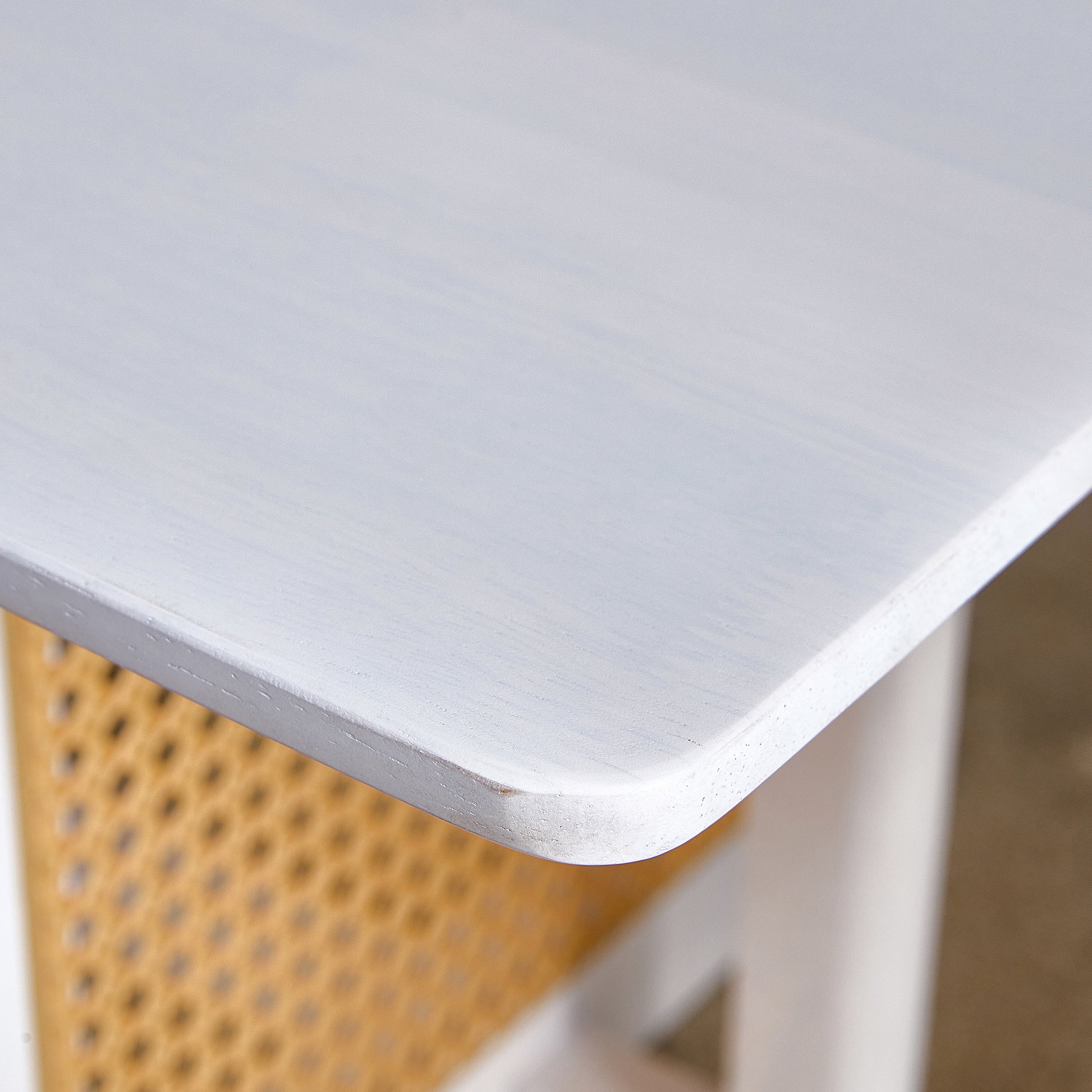 White washed wood table surface with rounded corner and visible grain texture