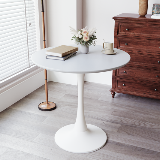 White round pedestal dining table with books and flowers