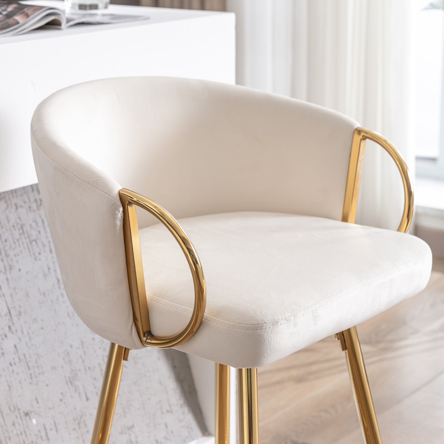 Cream velvet accent chair with curved arms and gold legs