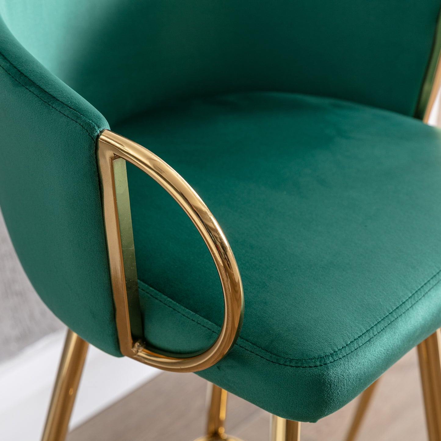 Green velvet accent chair with gold metal legs and armrest