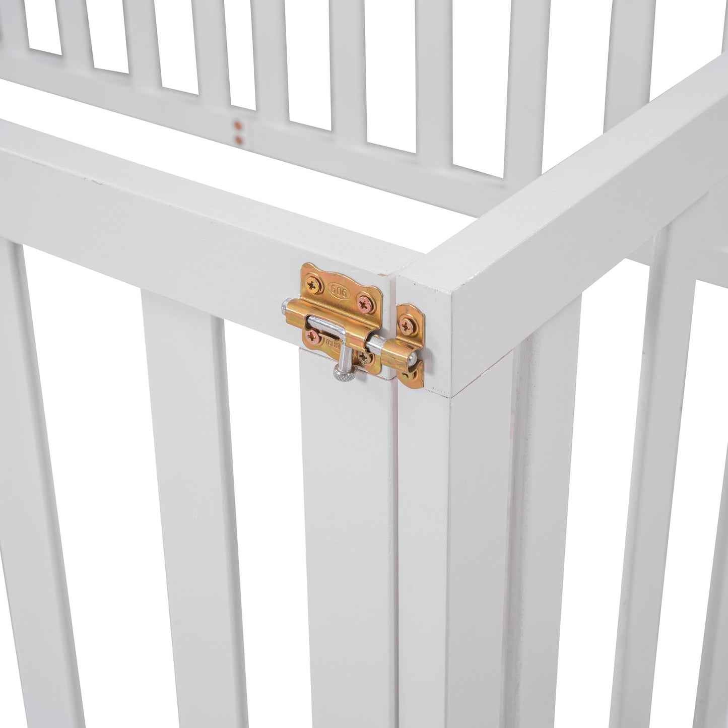 Closeup of a white wooden crib corner with a gold barrel bolt latch