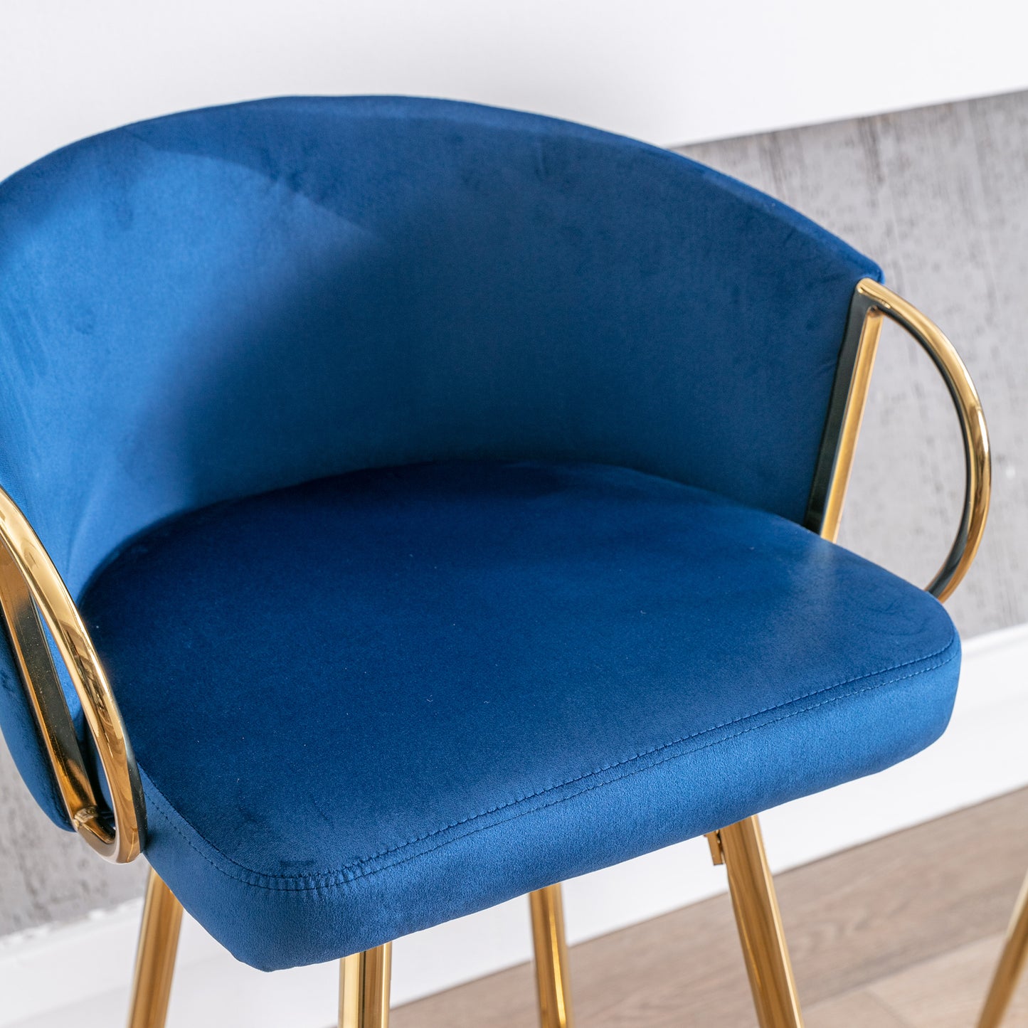 Deep blue velvet bar stool with gold legs and armrests