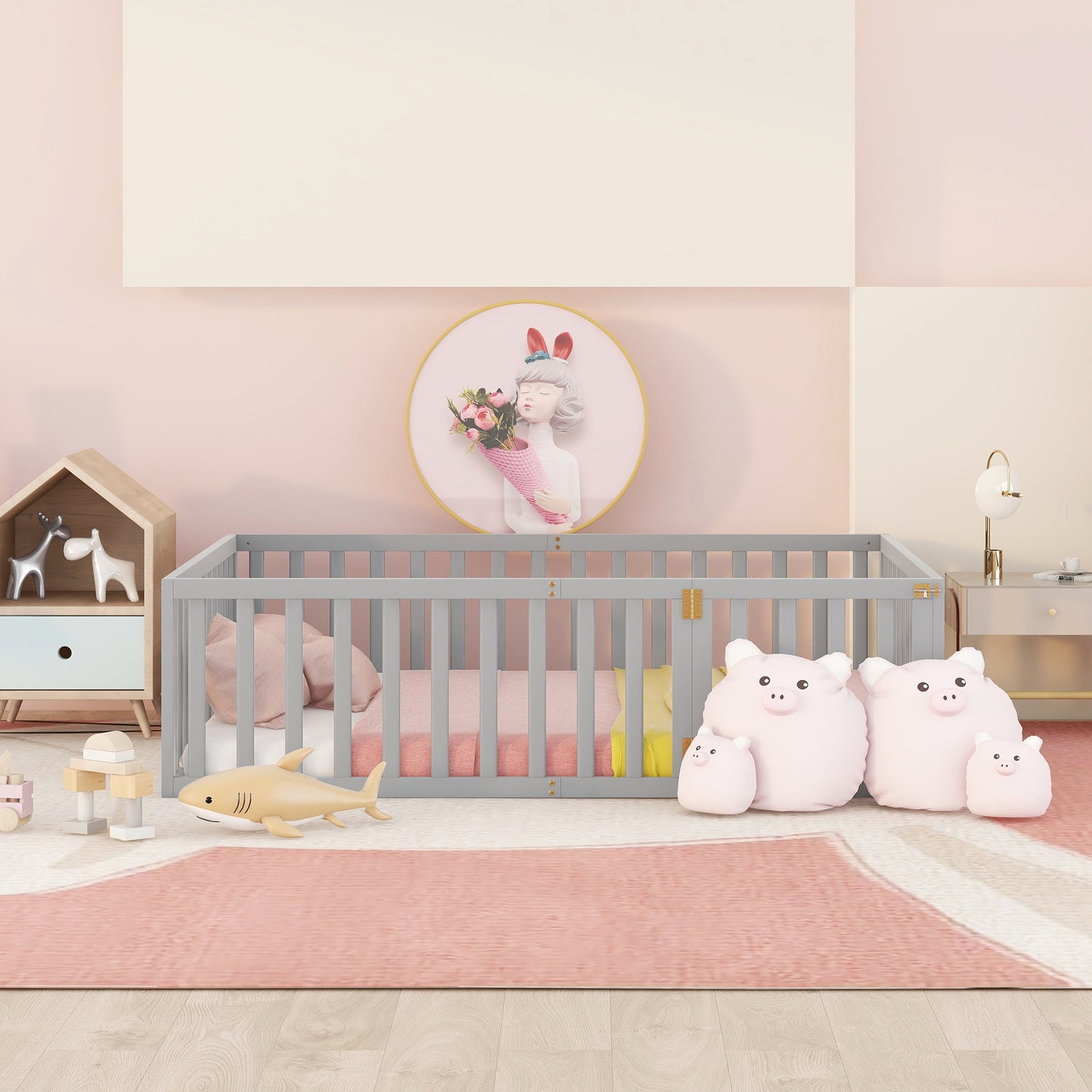 Gray wooden baby crib with pink bedding and stuffed animals