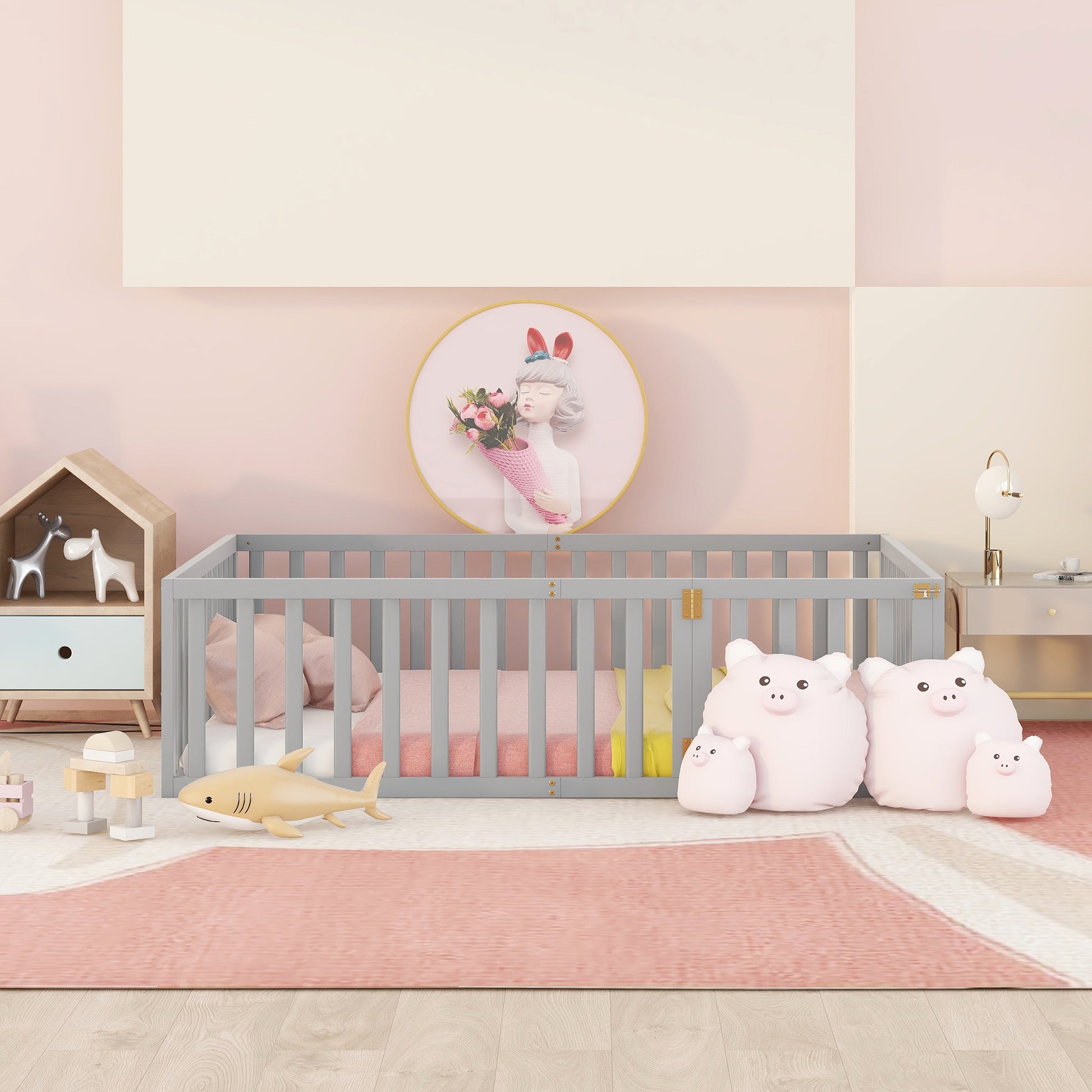 Gray wooden baby crib with pink bedding and stuffed animals