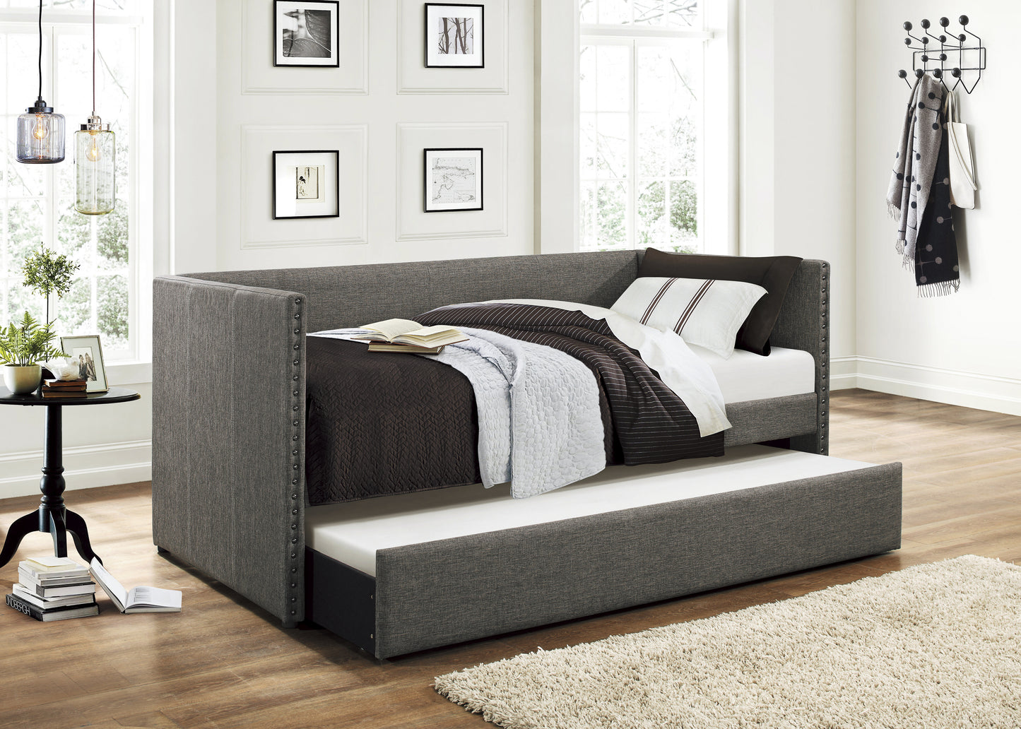 Gray fabric daybed with nailhead trim and trundle pulled out
