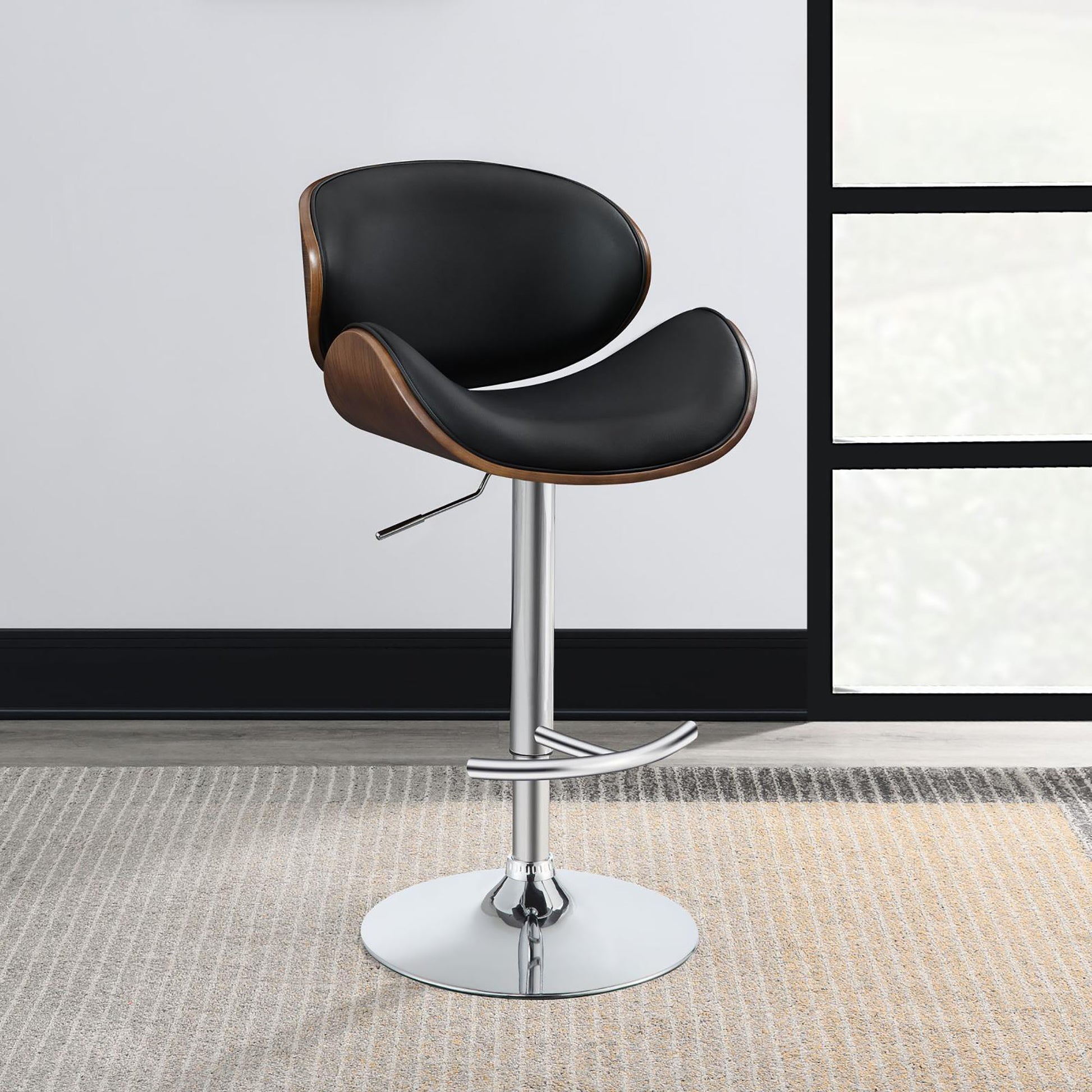 Black leather bar stool with curved wood accents and chrome base