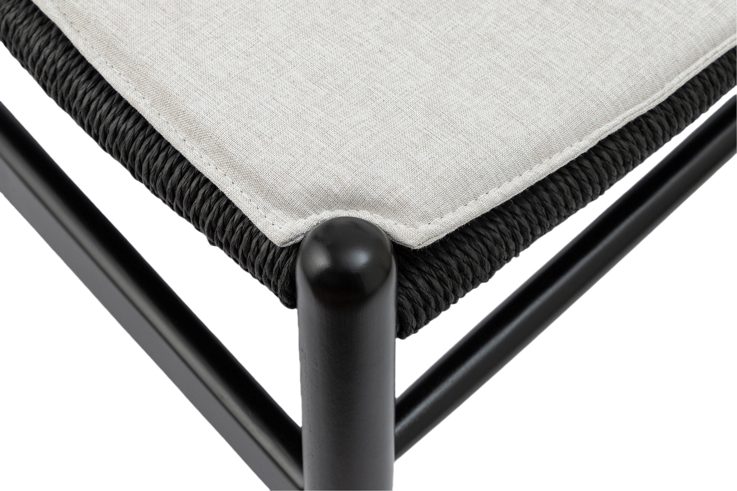 Closeup of a black woven seat detail with a light beige fabric cushion