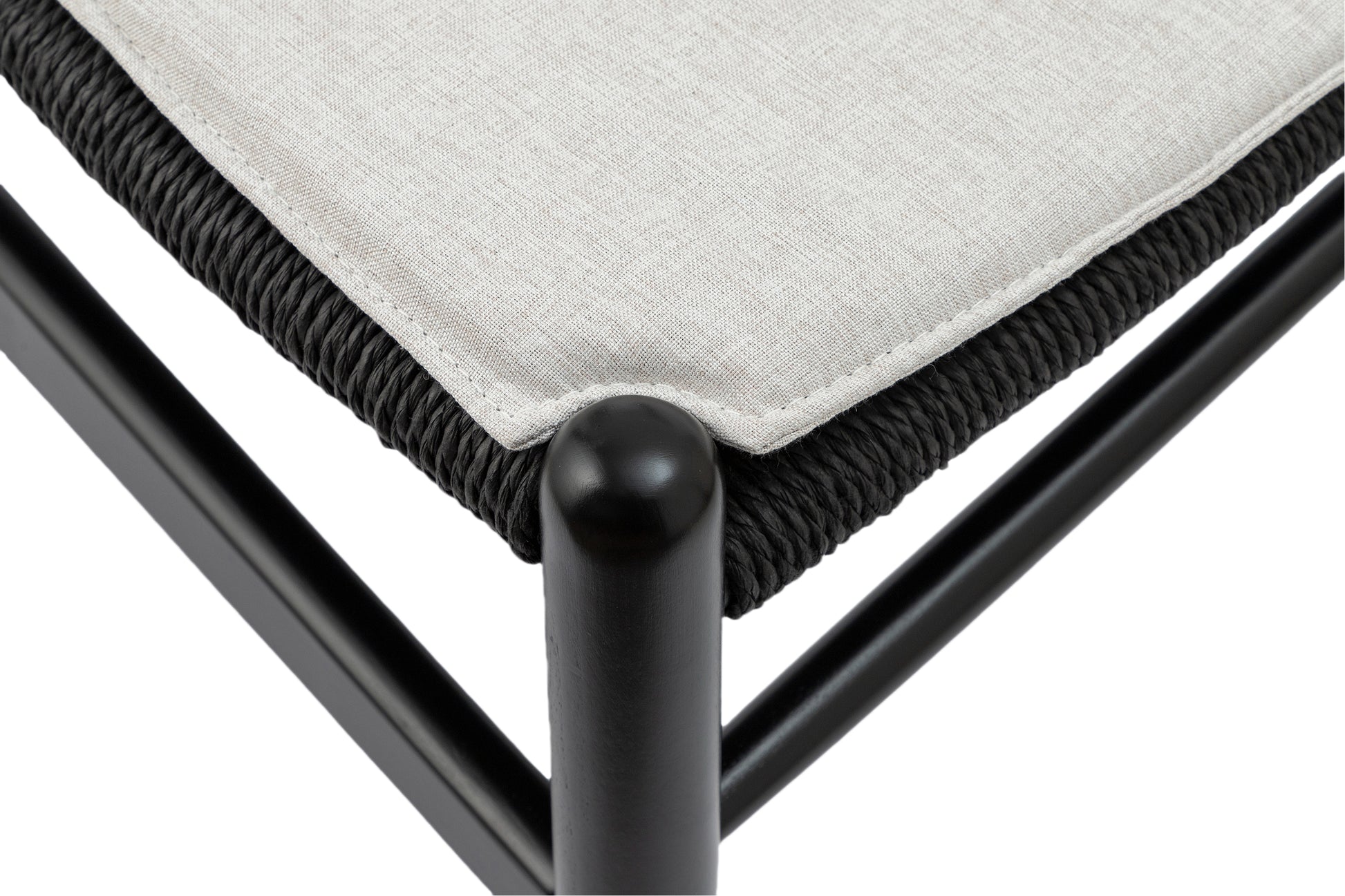 Closeup of a black woven seat detail with a light beige fabric cushion