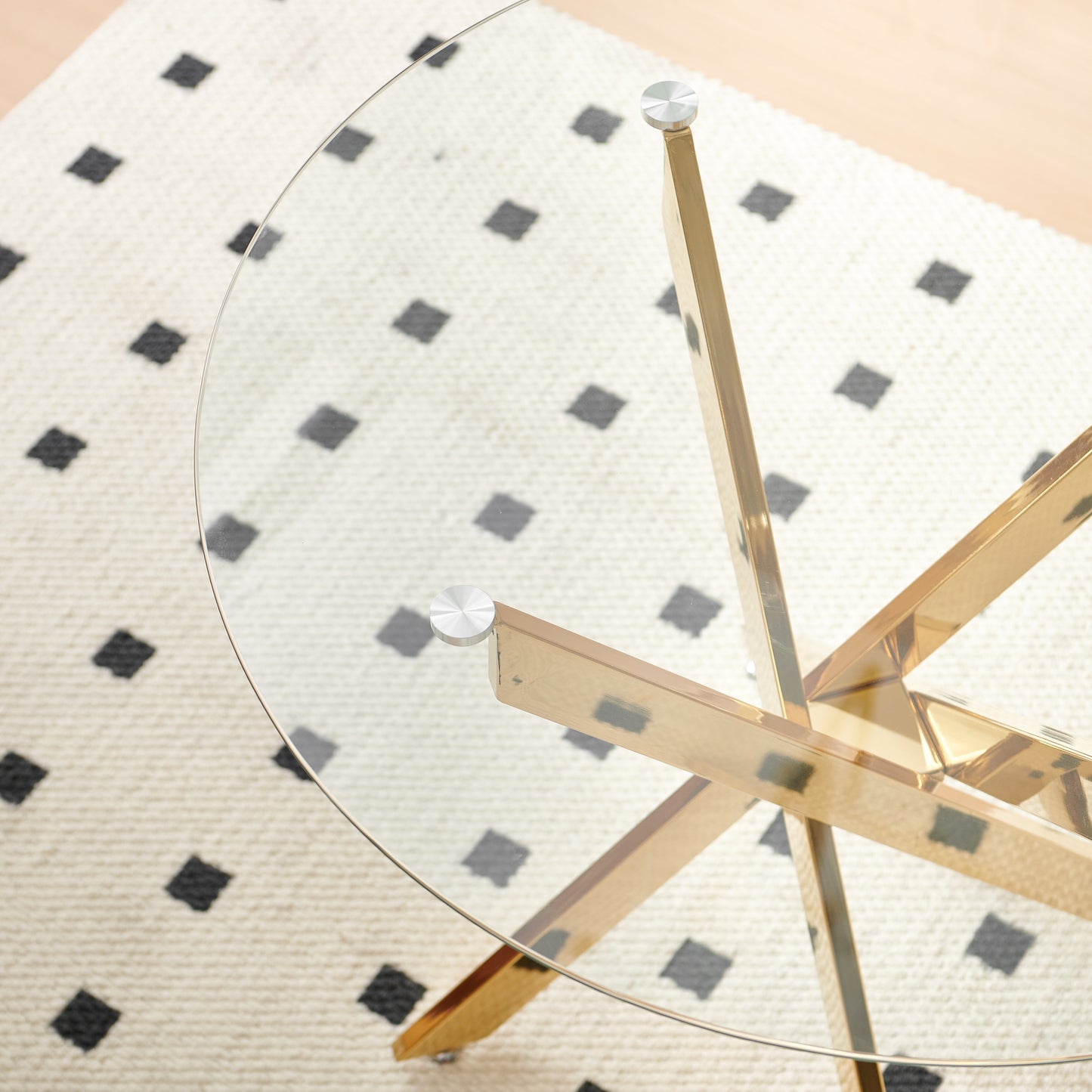 Clear glass tabletop on a gold geometric base coffee table
