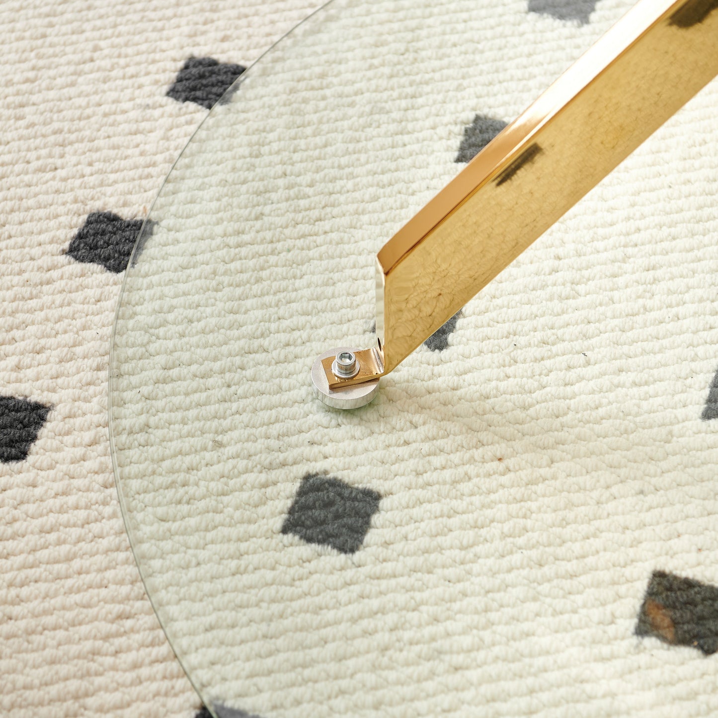 Round glass tabletop with gold metal leg support detail