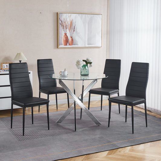 Four black faux leather dining chairs surrounding a round glasstop table with chrome pedestal base