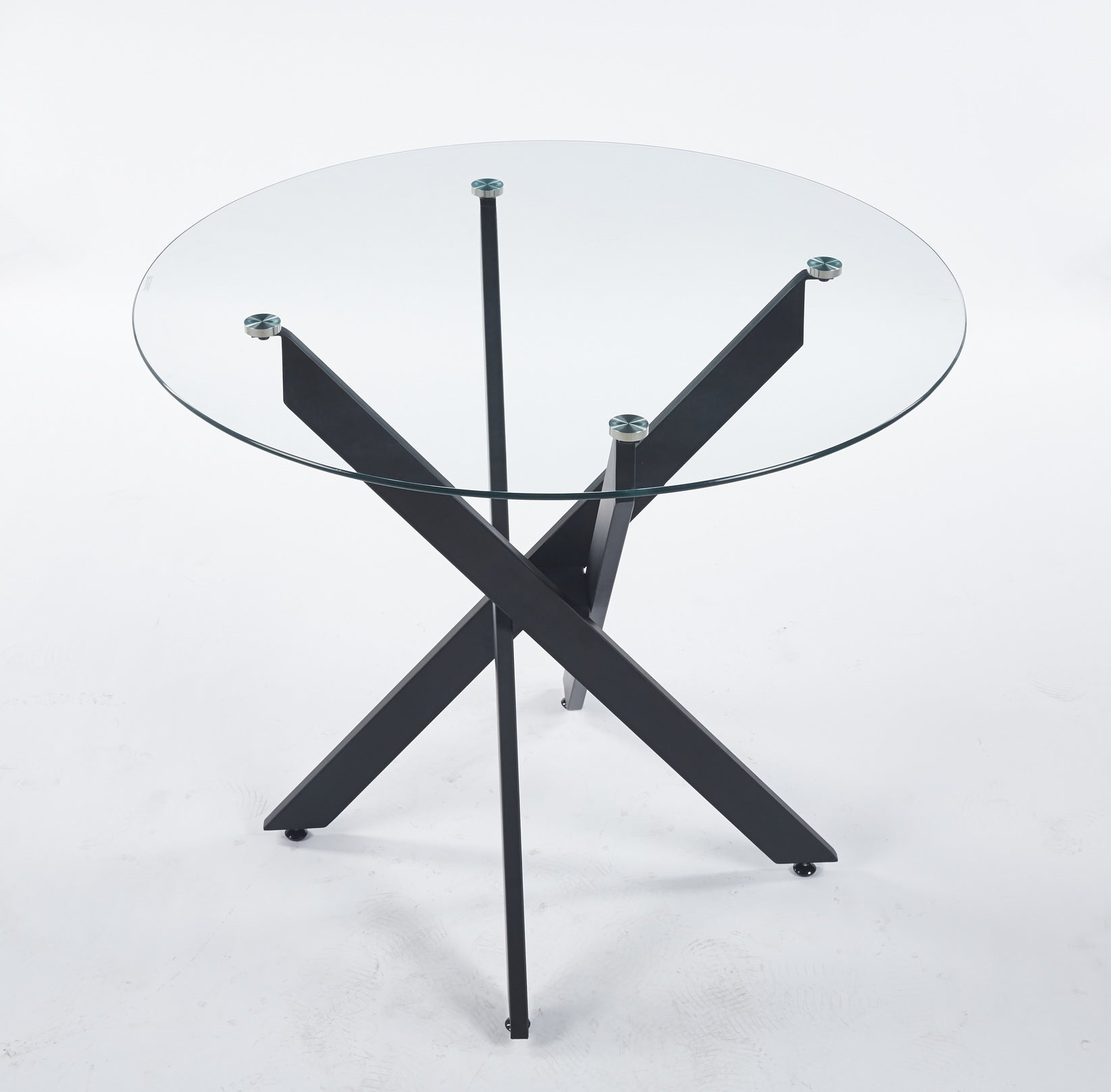 Round glass coffee table with black Xshaped metal legs and clear tabletop