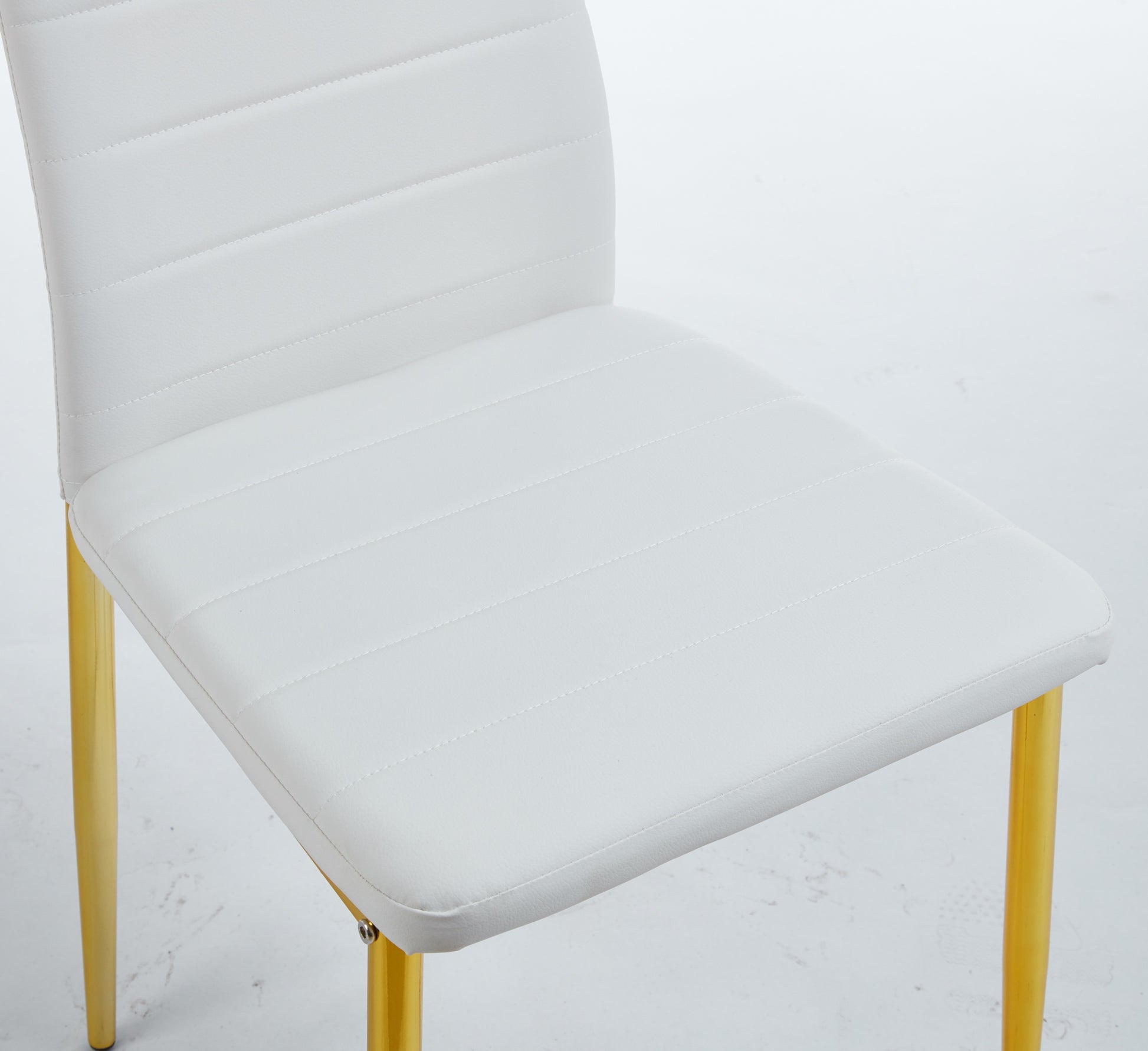 White faux leather dining chair with horizontal stitching and gold legs