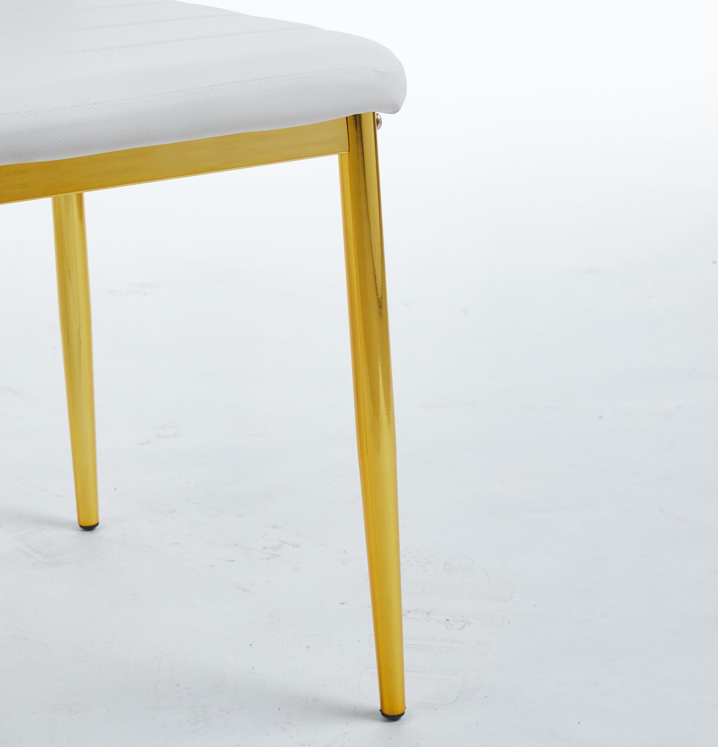 White upholstered dining chair with sleek gold legs