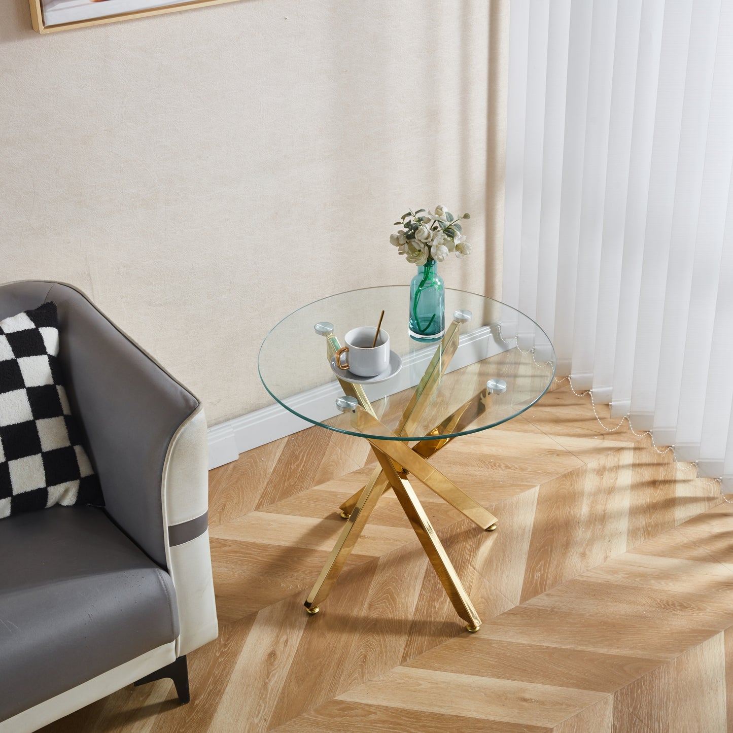 Round glass coffee table with gold geometric base and floral decor