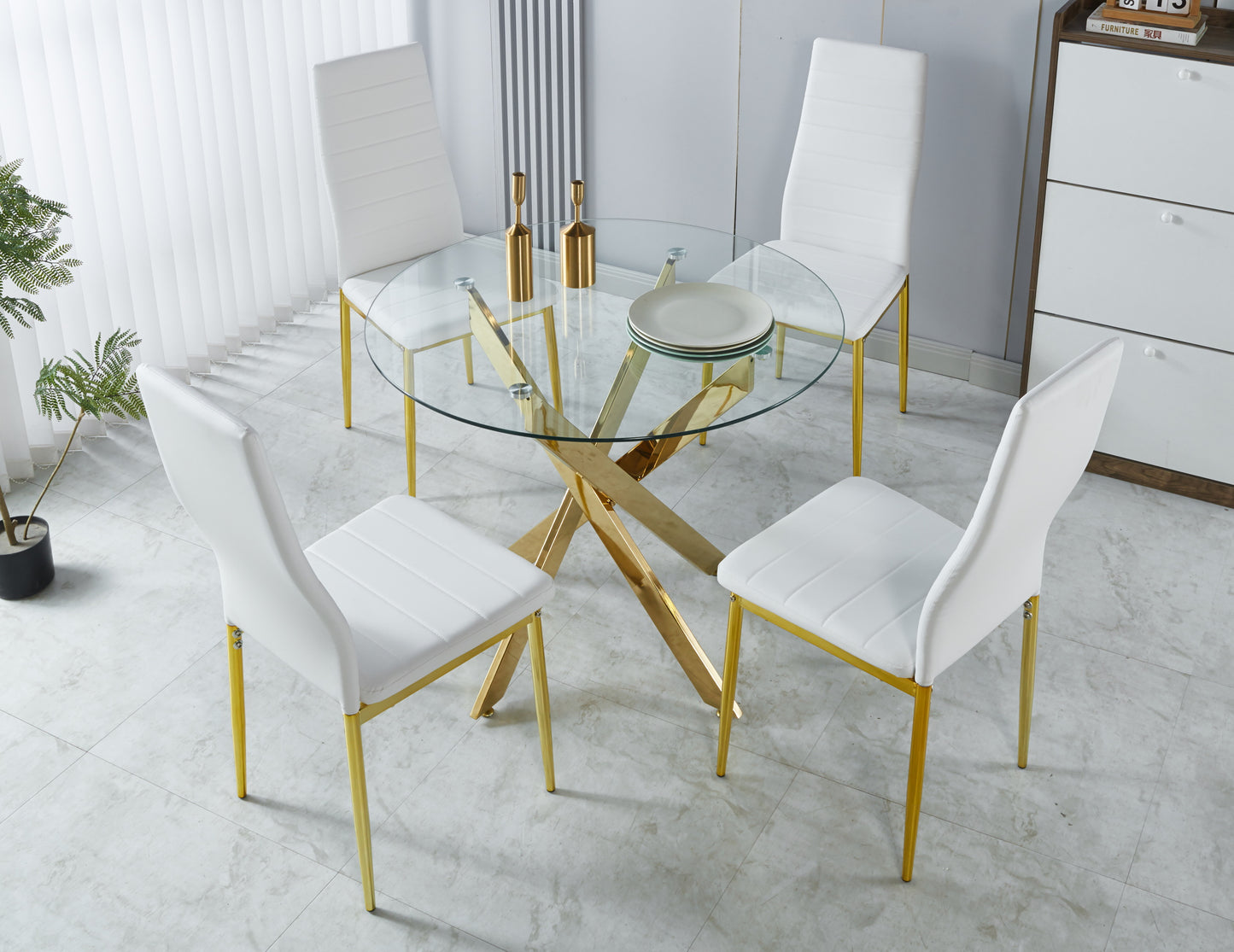 Modern glass dining table with gold base and four white chairs