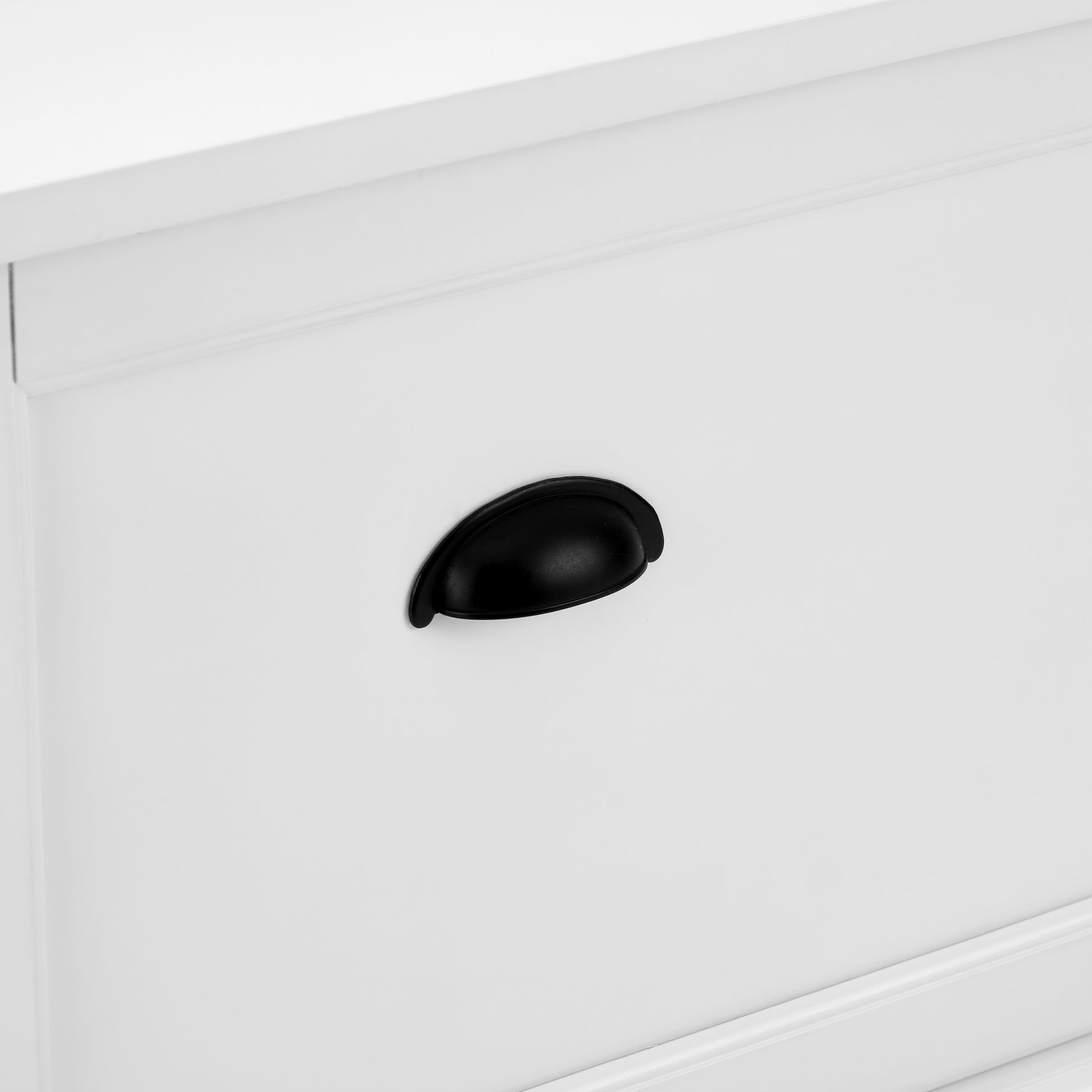 White cabinet door with a black cup drawer pull