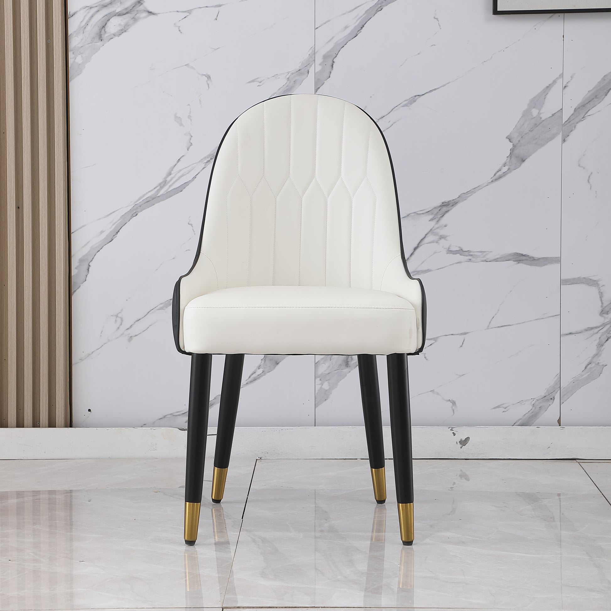 White upholstered dining chair with tufted seat and black metal legs with gold accents