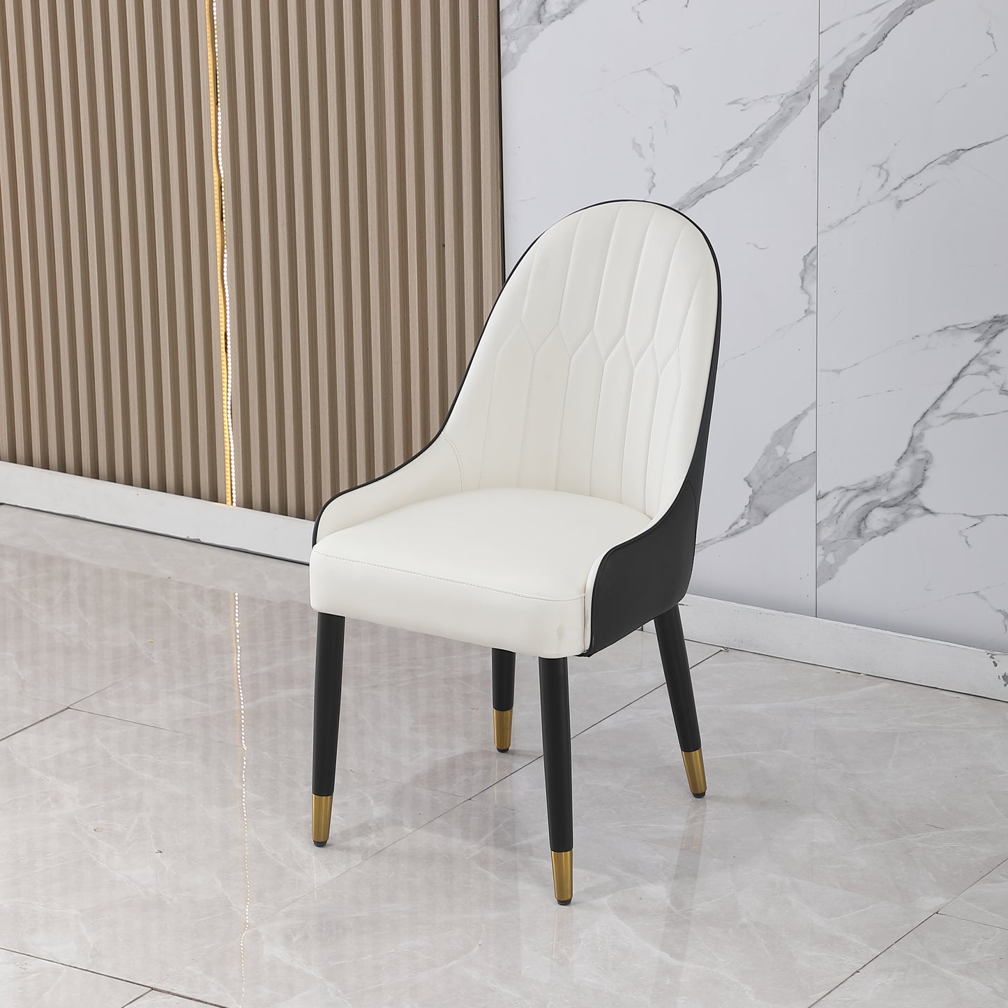 White upholstered dining chair with black accents and goldtipped black legs