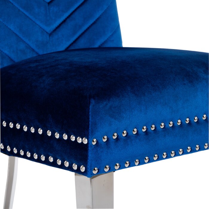 Deep blue velvet tufted chair with silver nailhead trim and metal legs