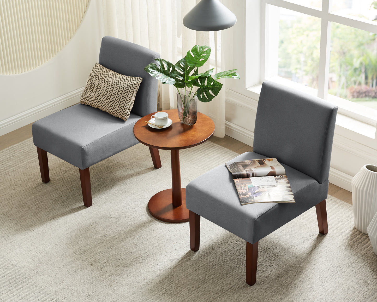 Gray fabric accent chair with wooden legs and decorative pillow