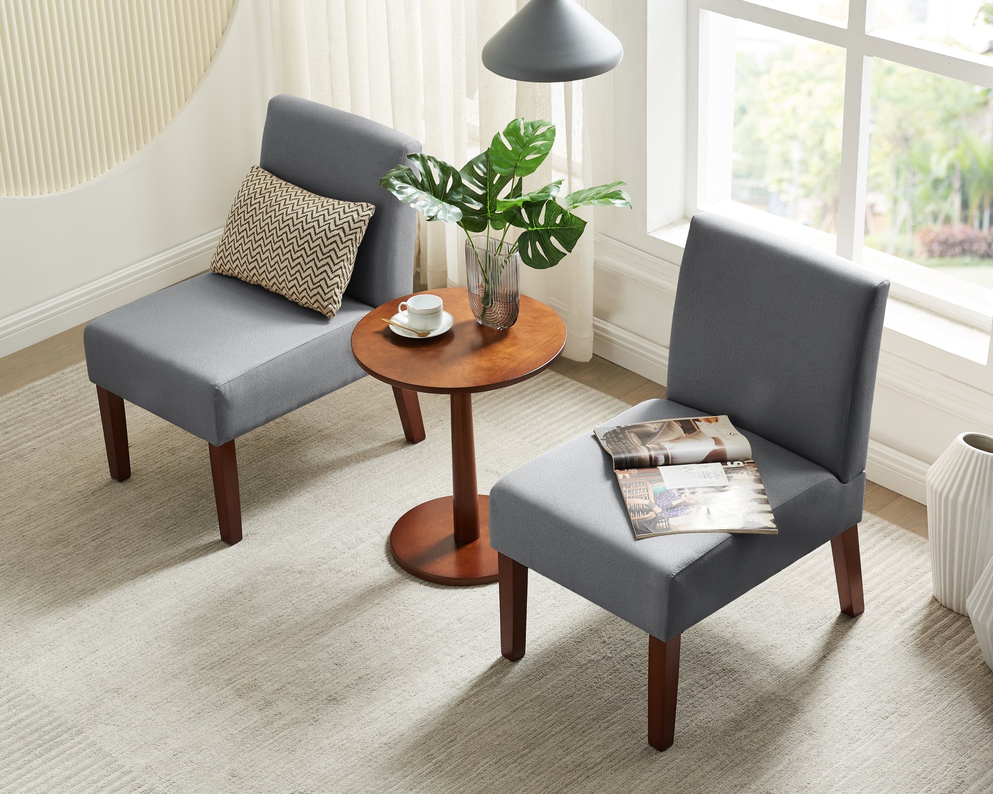Gray fabric accent chair with wooden legs and decorative pillow