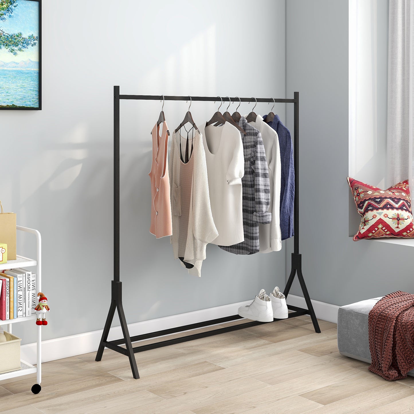 Black metal garment rack displaying a pastel pink vest beige knit cardigan white tshirt and plaid shirt
