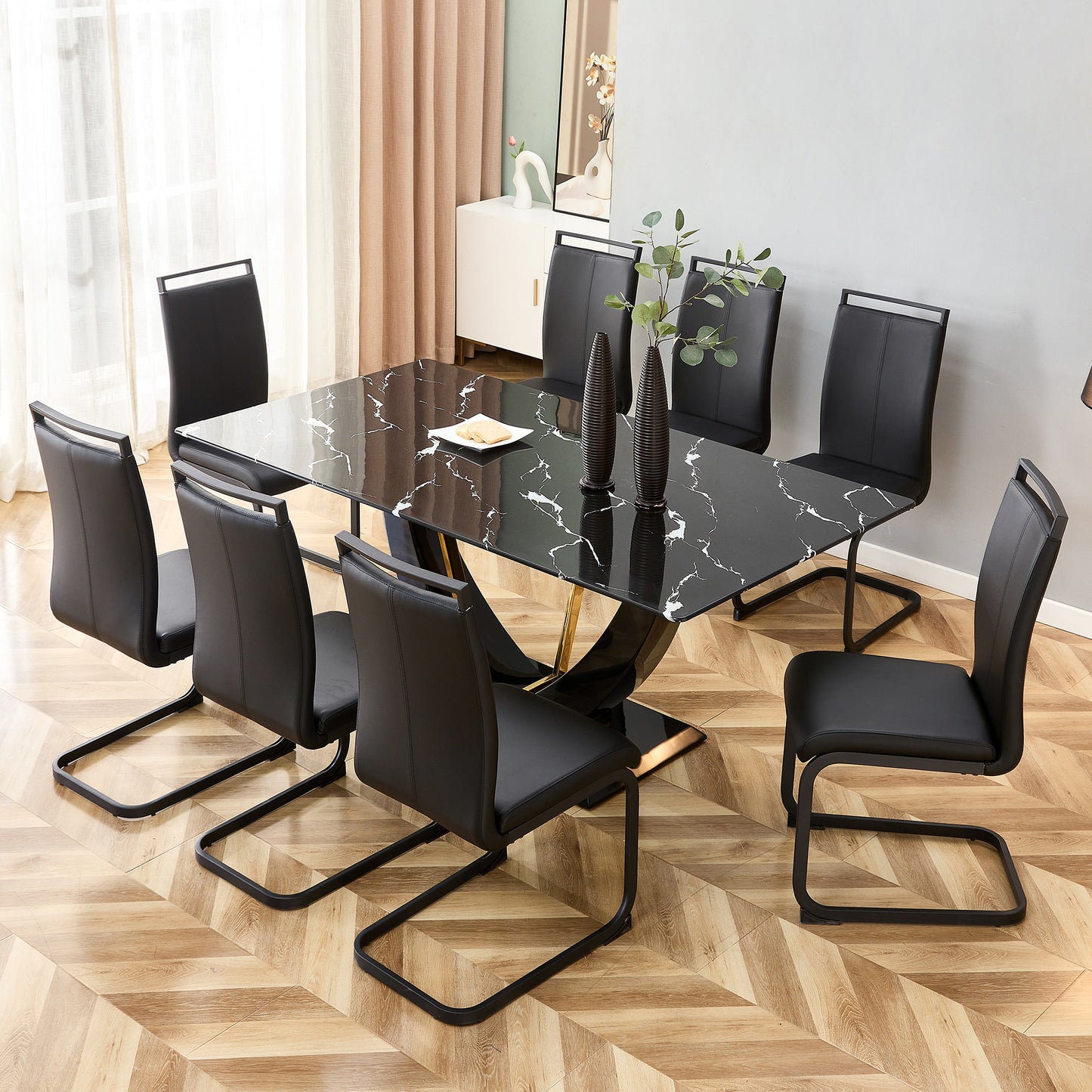 Black marble dining table with gold base and eight black leather chairs