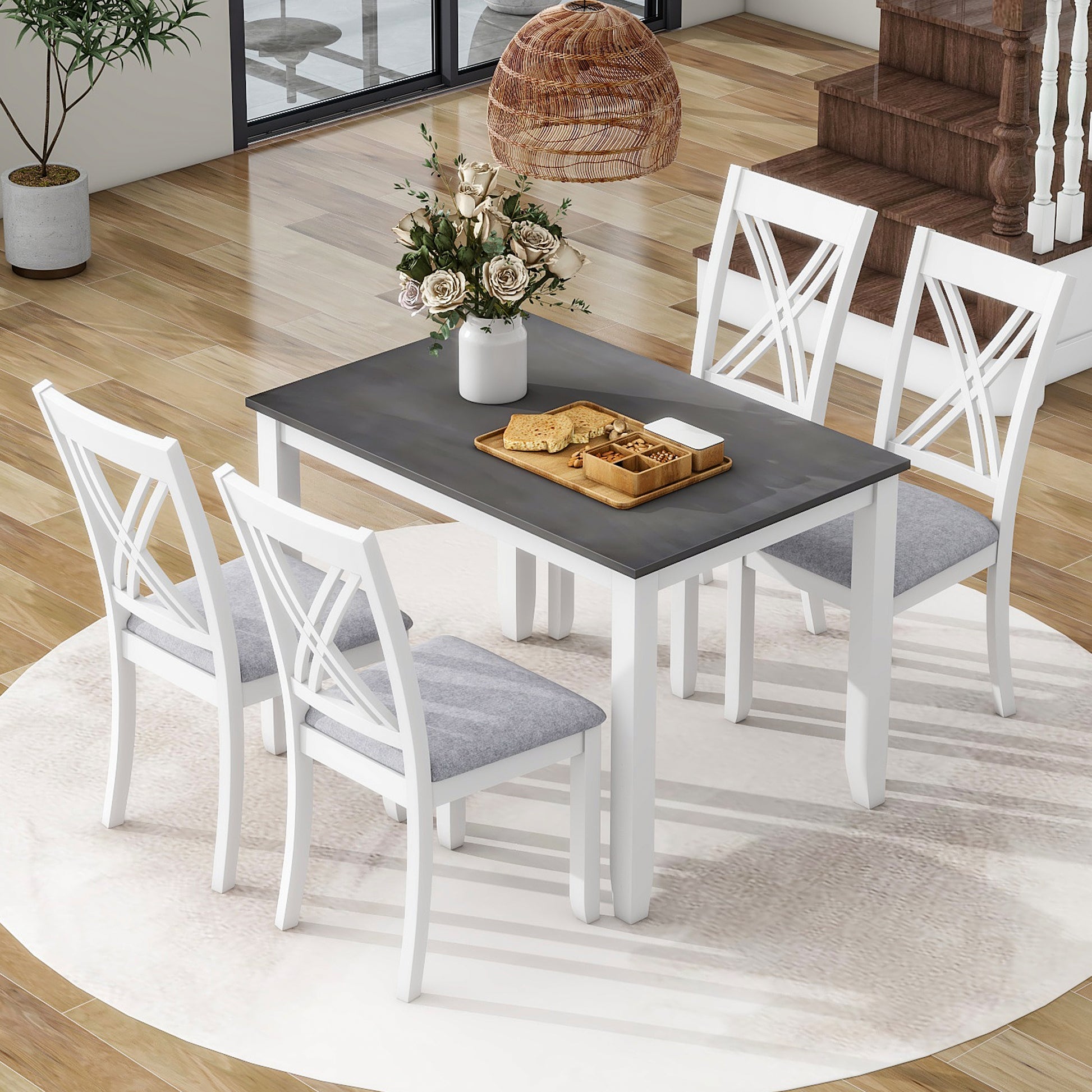 White dining table with gray top and four upholstered chairs with Xback design