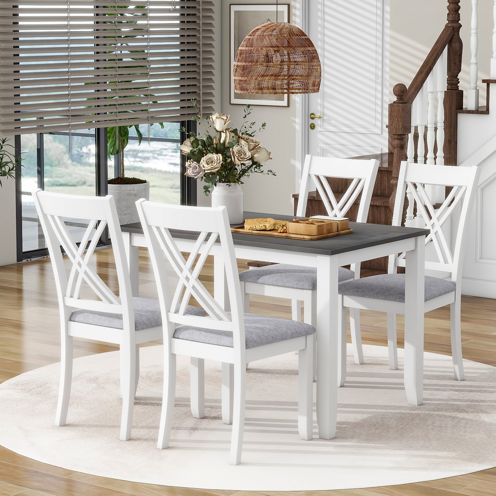White dining table with four grey upholstered chairs