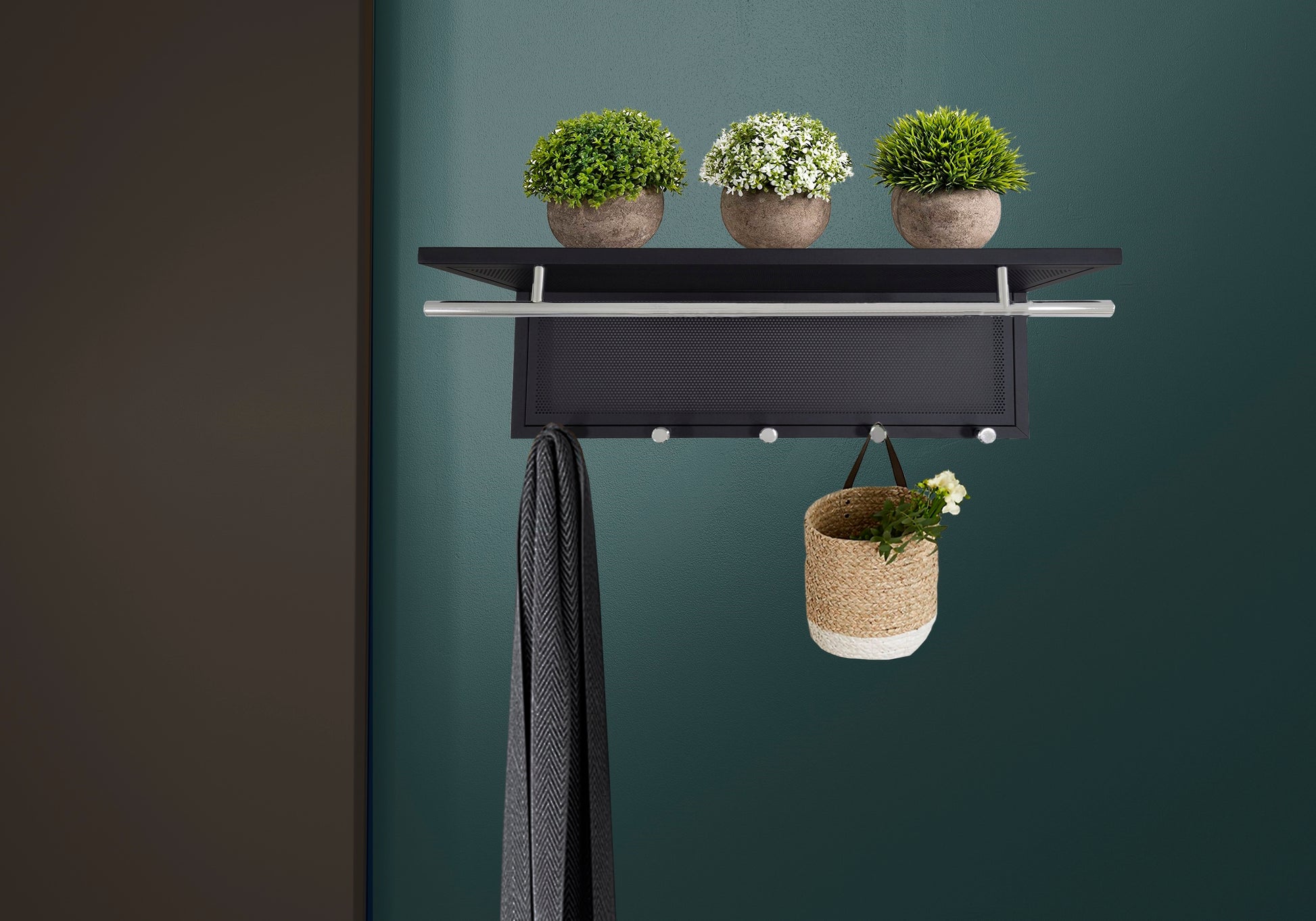 Black modern entryway rack with silver bar and hooks holding a scarf and basket