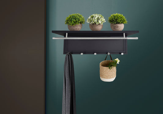 Black modern entryway rack with silver bar and hooks holding a scarf and basket