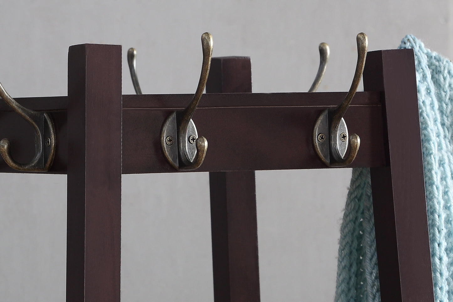 Dark brown wooden coat rack with antique brass double hooks