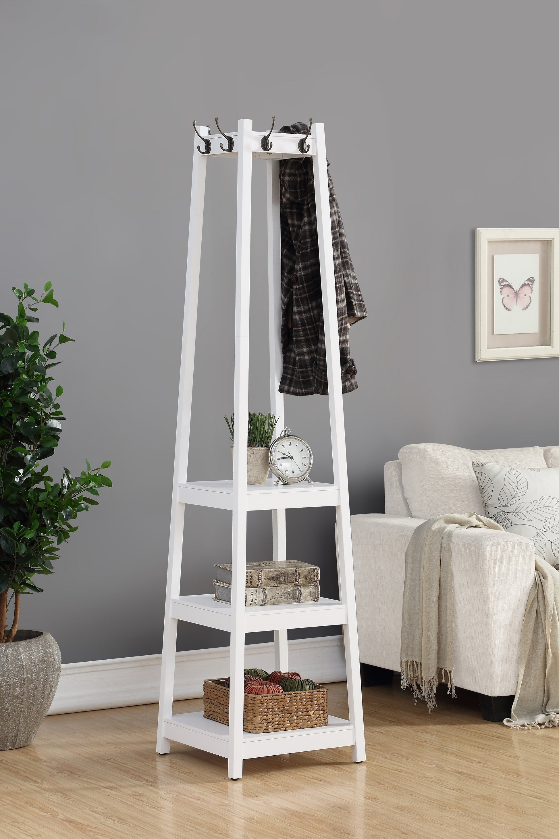 White wood coat rack with shelves holding decorative items