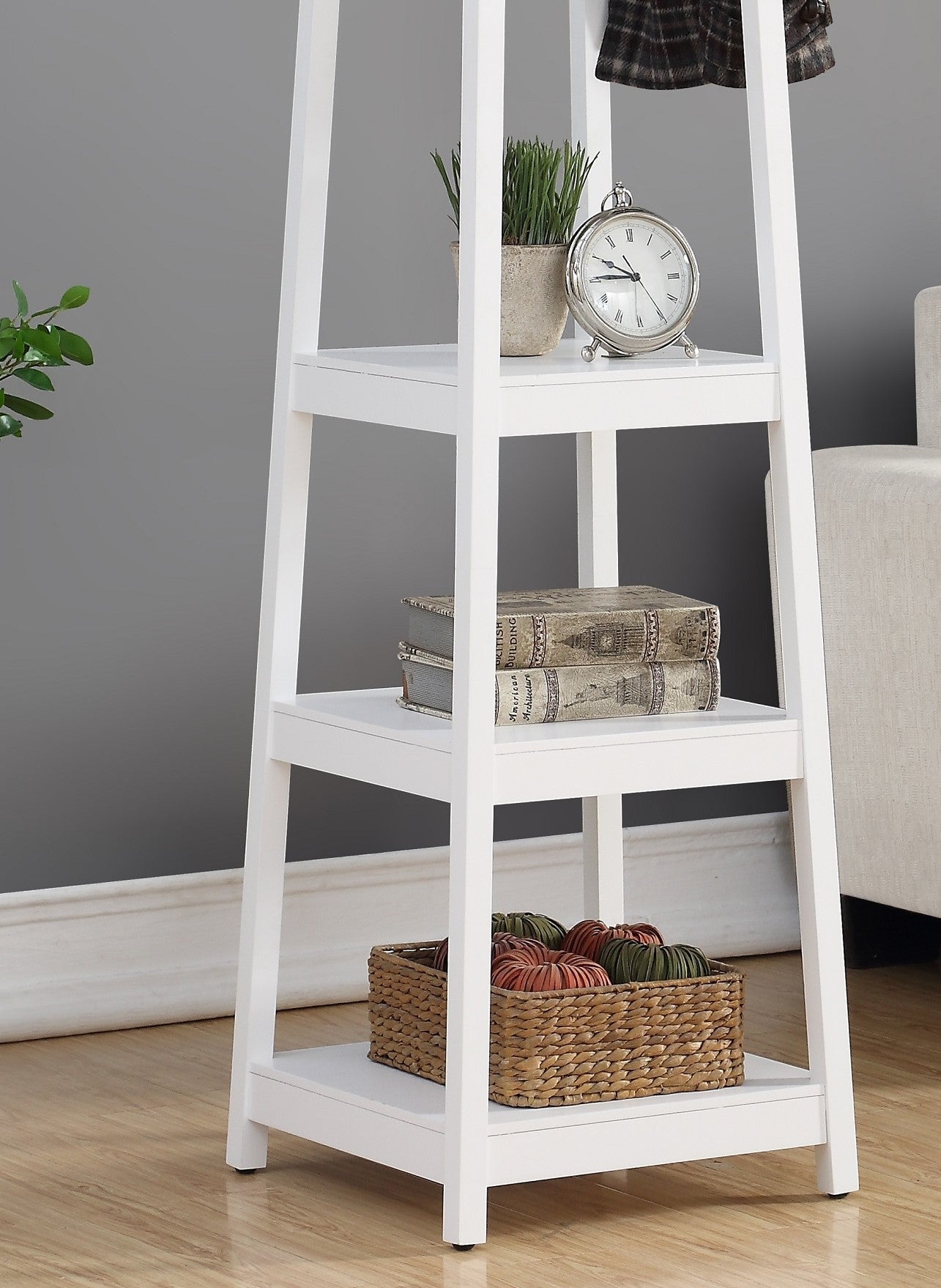 White ladder shelf with decorative items including a clock and books