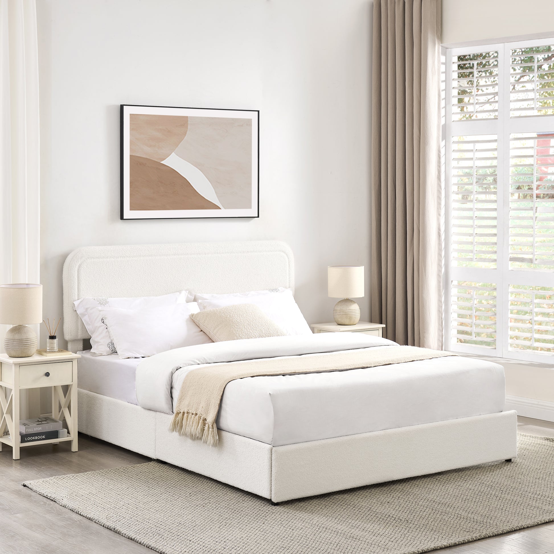 Cream boucl upholstered bed frame with plush bedding and decorative pillows