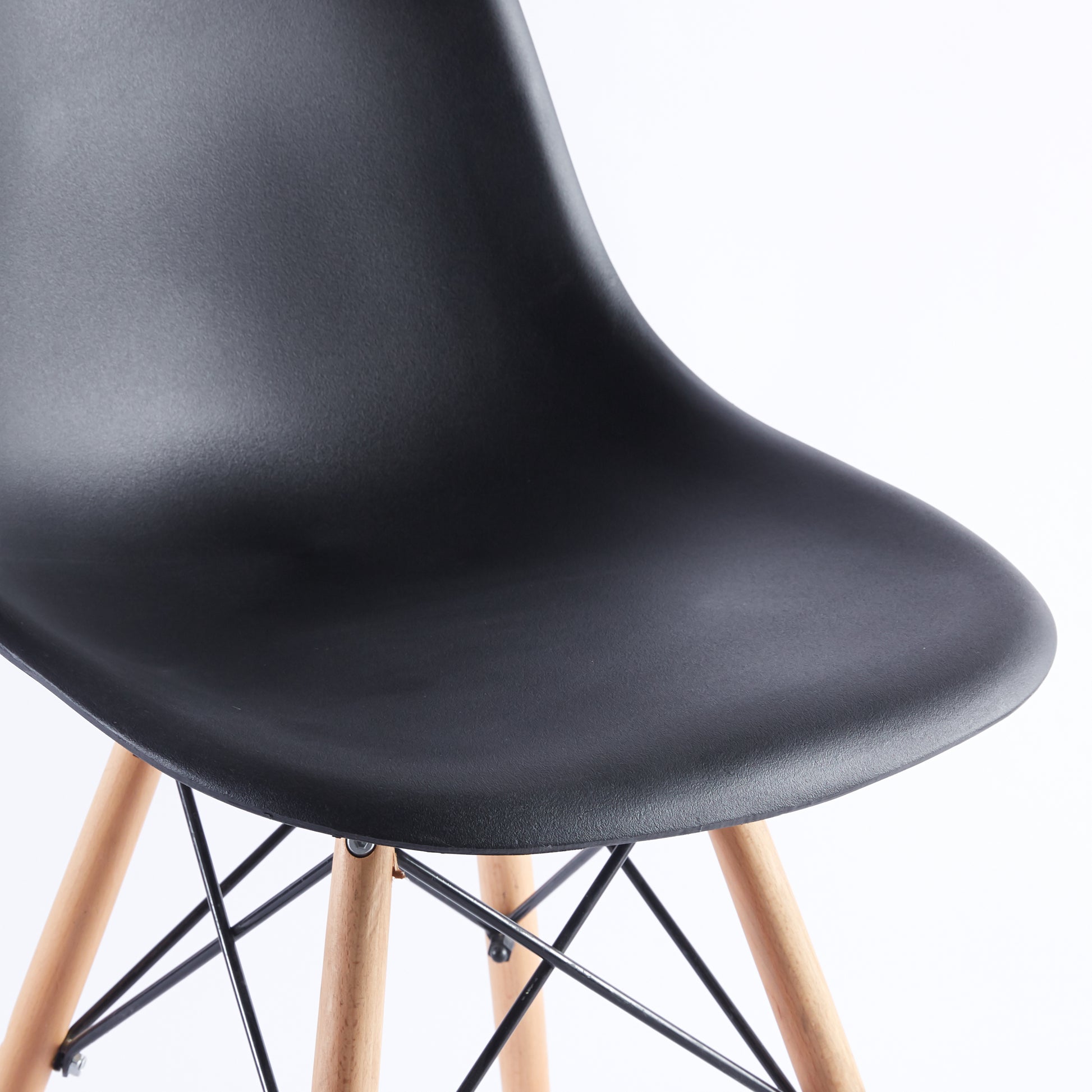 Black molded plastic chair seat with natural wood dowel legs and black cross bracing