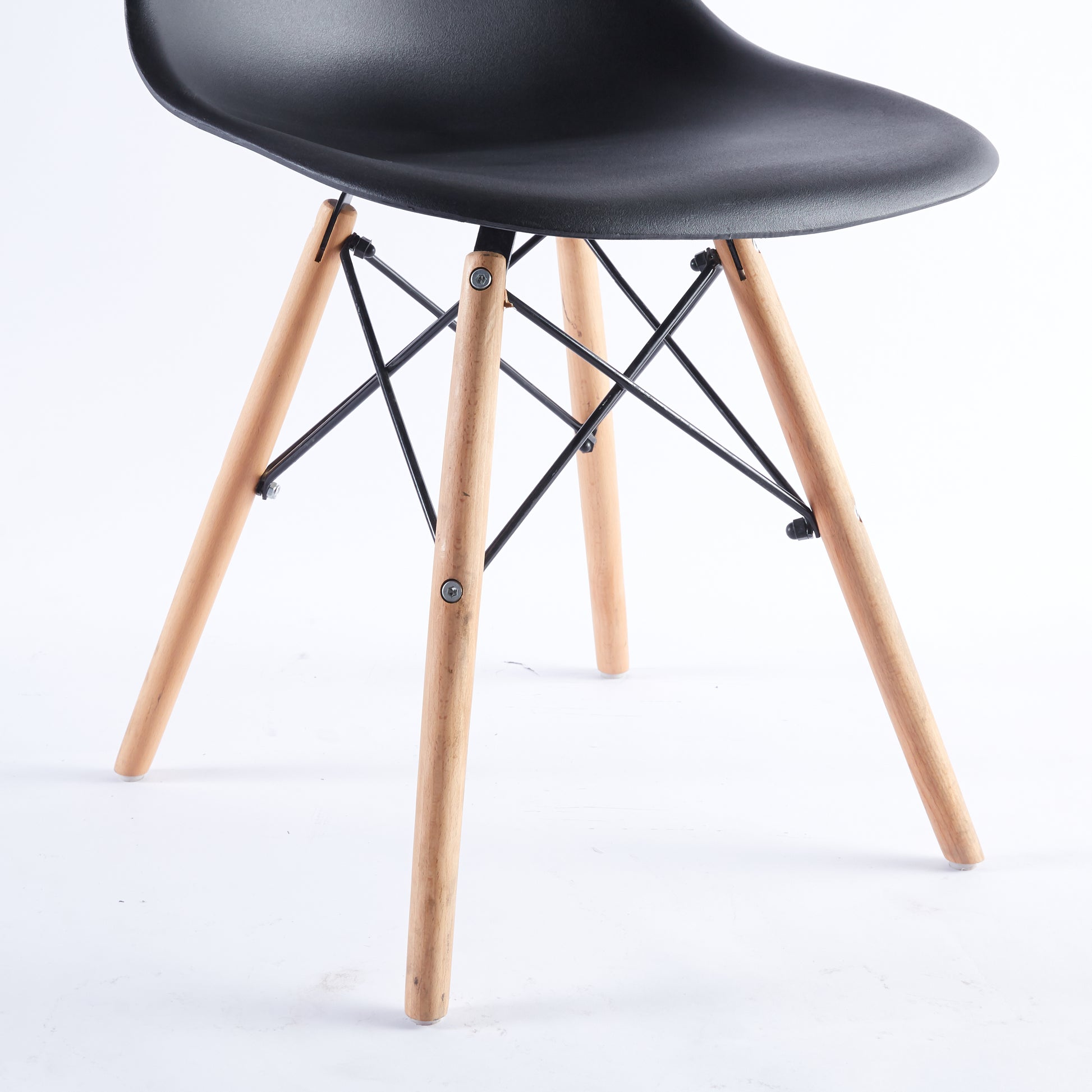 Black plastic molded chair with natural wood dowel legs and black metal cross supports