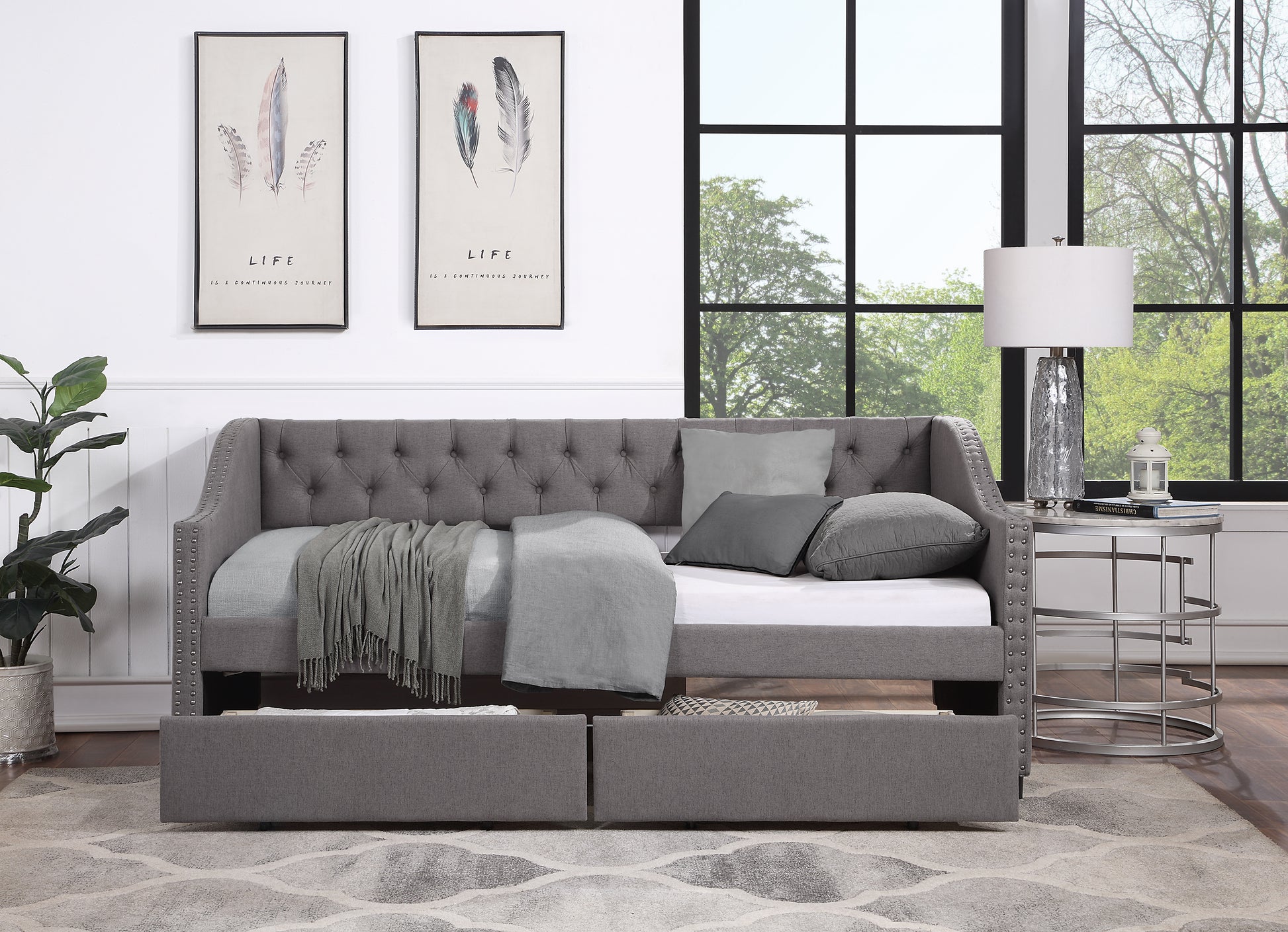 Tufted grey fabric daybed with nailhead trim and storage drawers