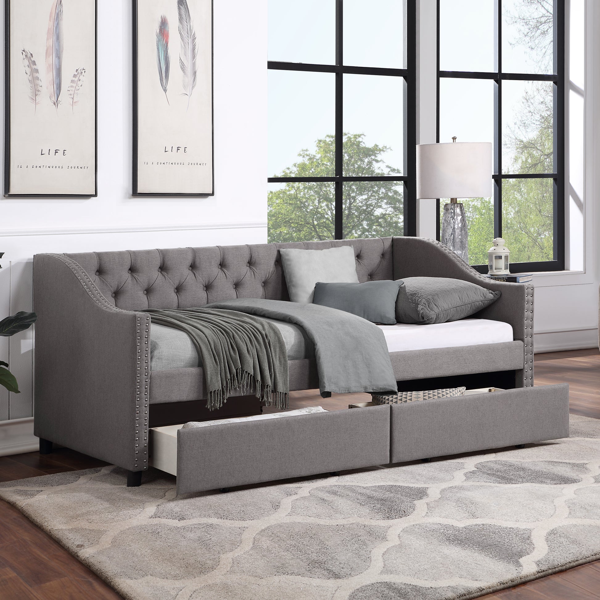 Gray upholstered daybed with tufted back nailhead trim and two storage drawers