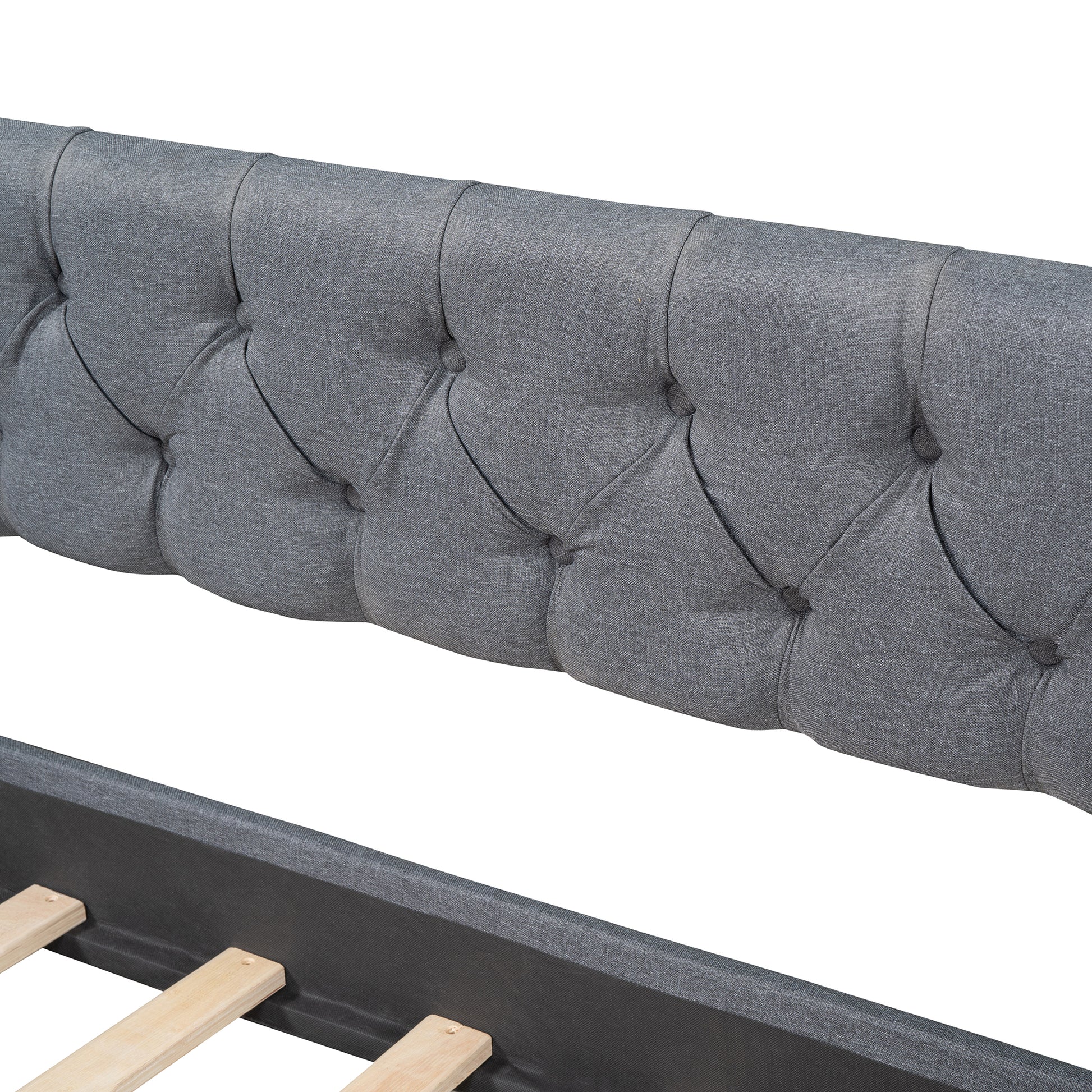 Closeup of grey tufted fabric headboard with wooden bed slats